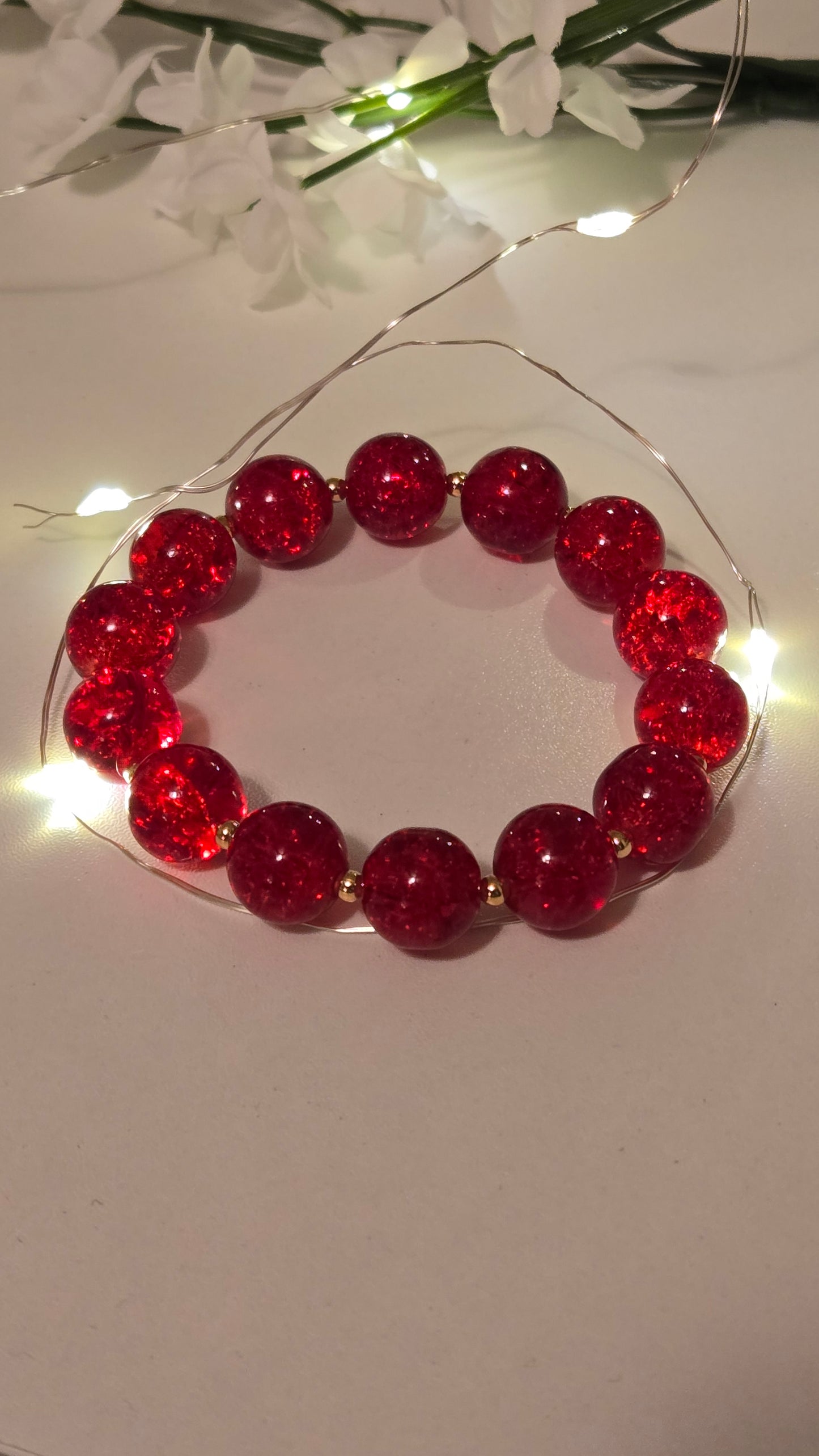 Ruby Glow Bracelet draped gracefully over a fabric background