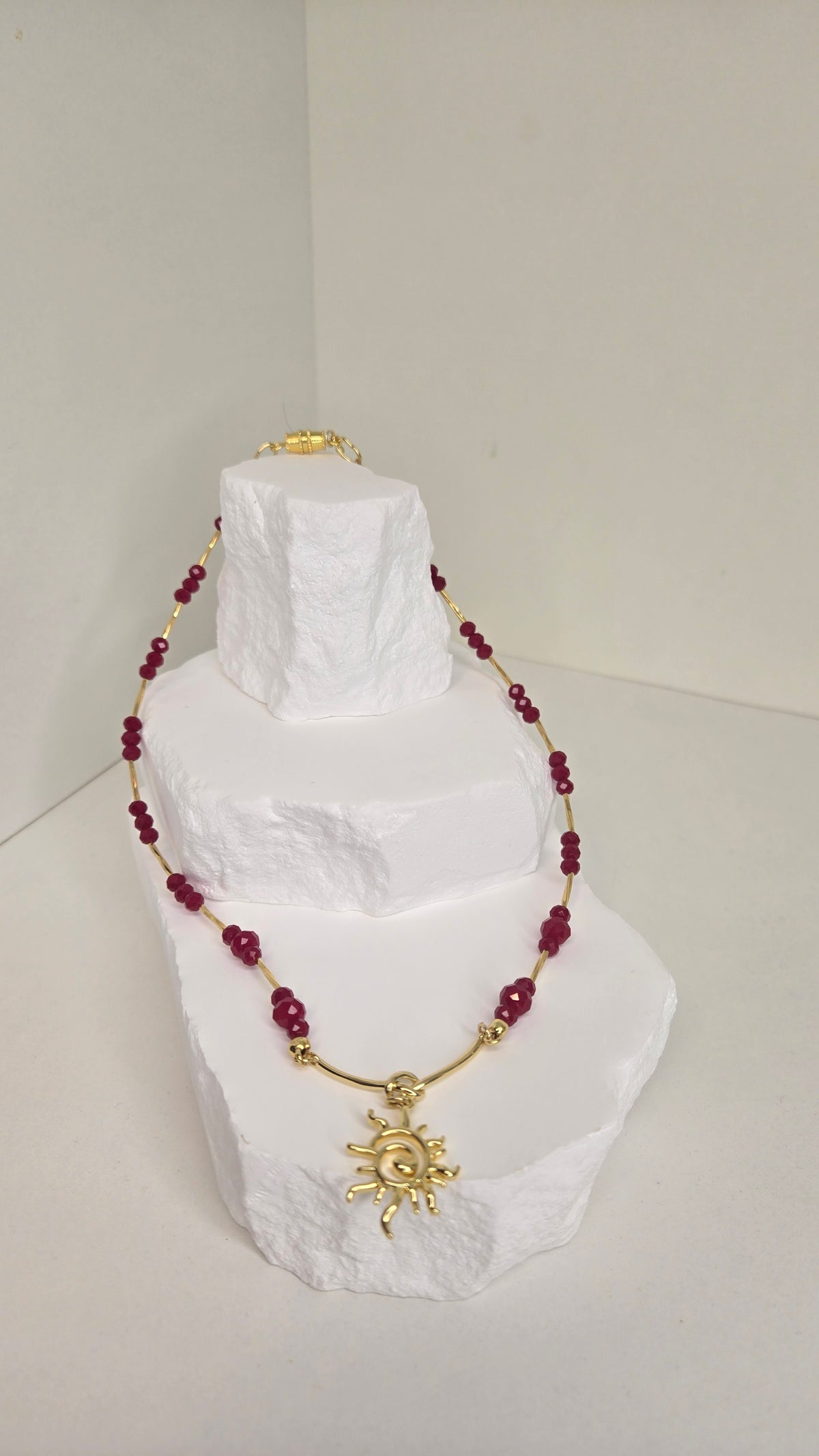 Sun of Love Necklace with faceted red gemstone beads and a gold-tone sun pendant