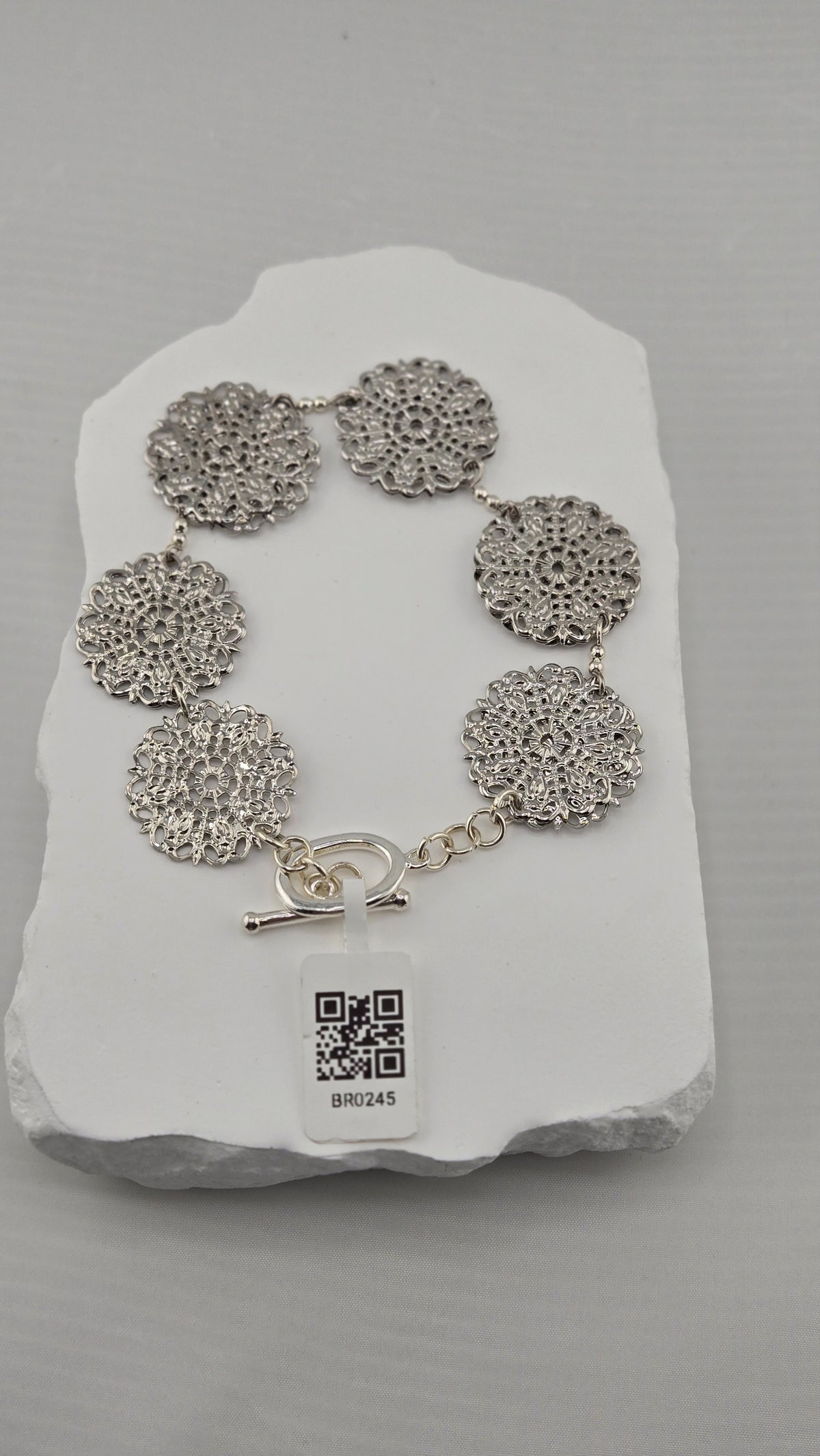 Rosette Openwork Bracelet laid flat on a white stone