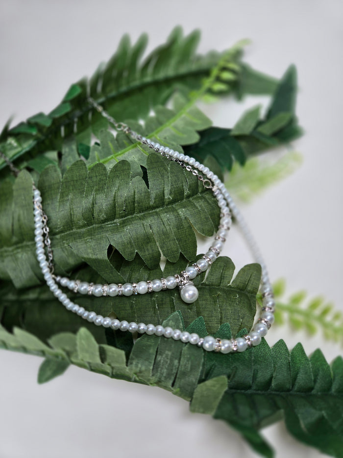 Moonlight Halo Necklace with two layers of white pearl-like beads and silver spacers