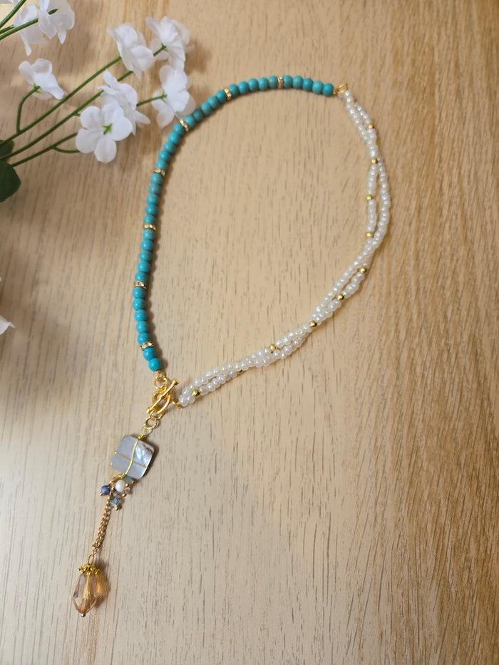 Pearl Mirage Asymmetric Necklace with turquoise-colored chips, white beads and gold-tone chain