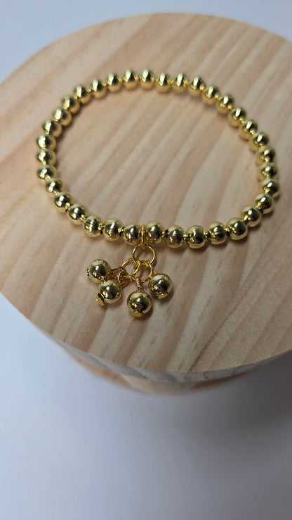 Golden Glow Bracelet of gold-tone round beads with four small ball charms