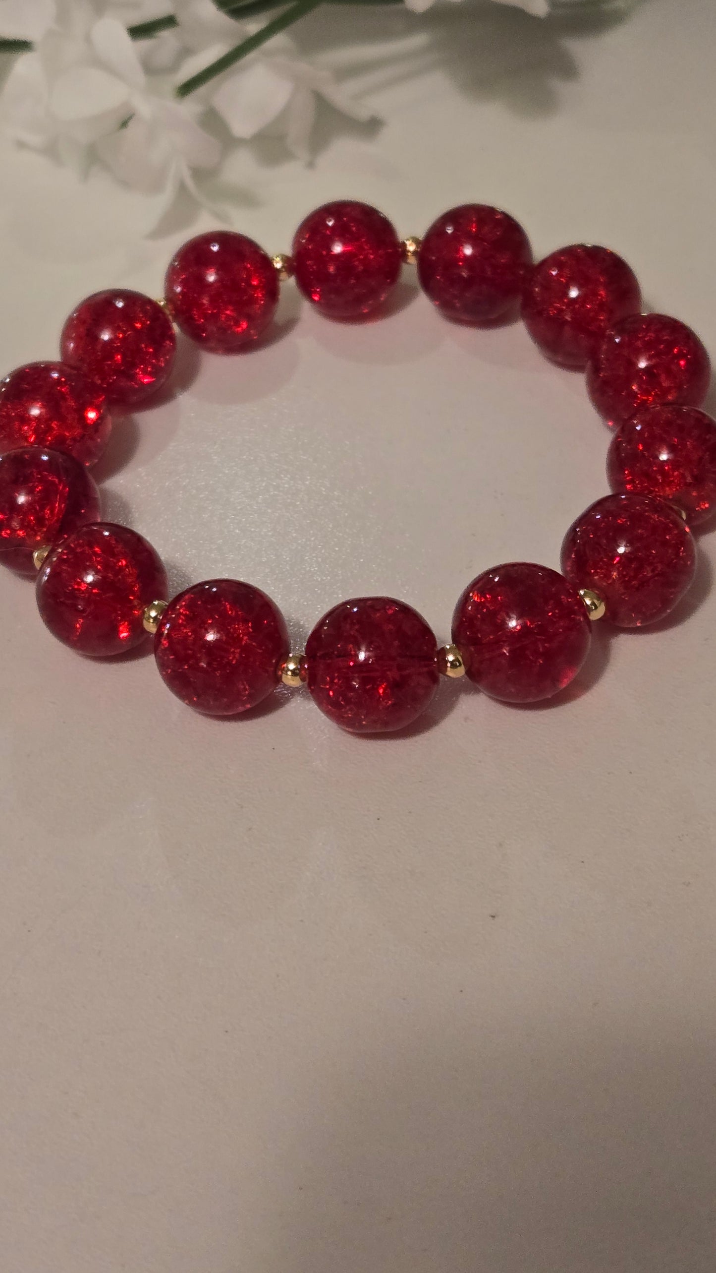 Ruby Glow Bracelet elegantly displayed on a wooden surface