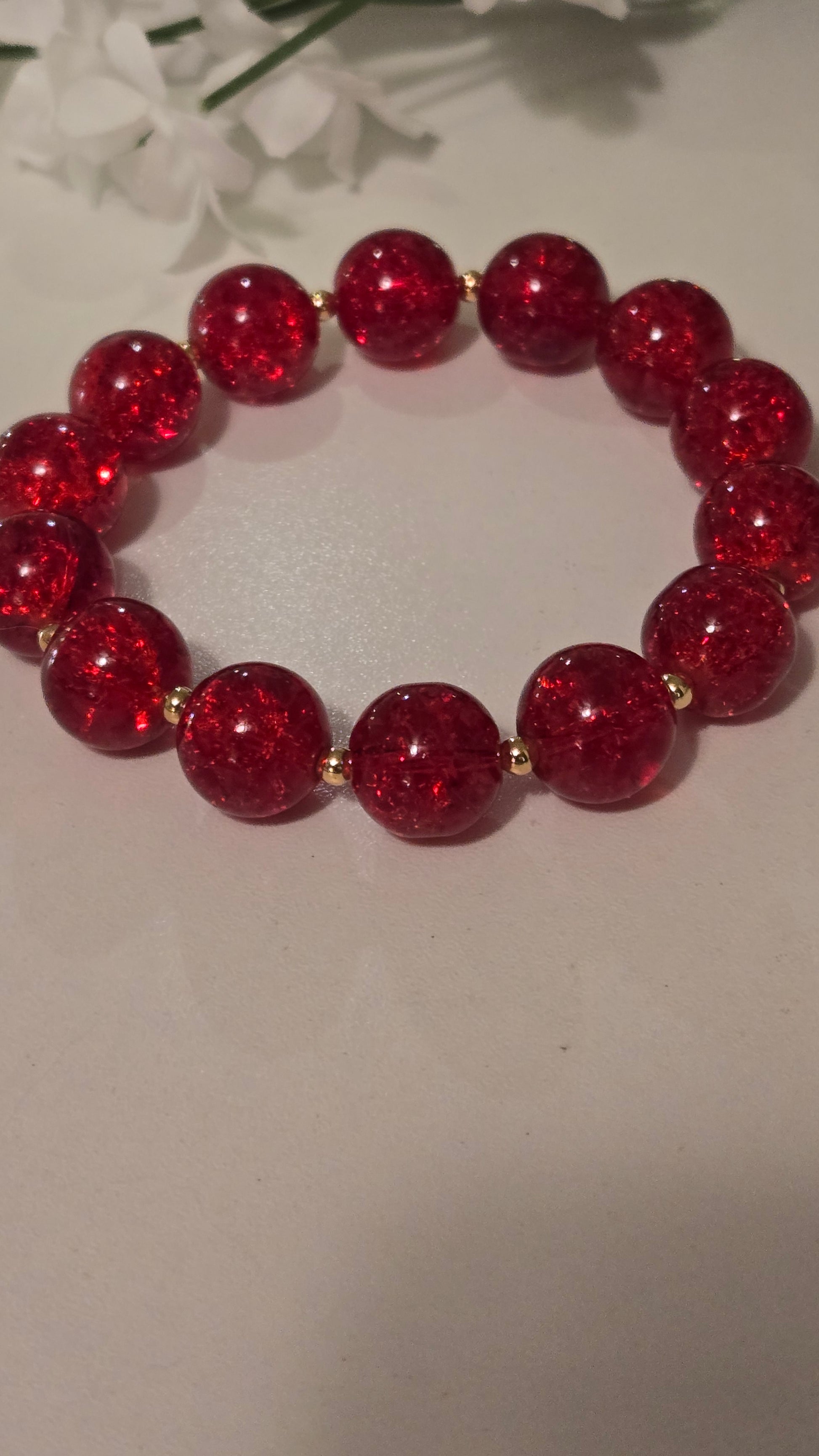 Ruby Glow Bracelet elegantly displayed on a wooden surface
