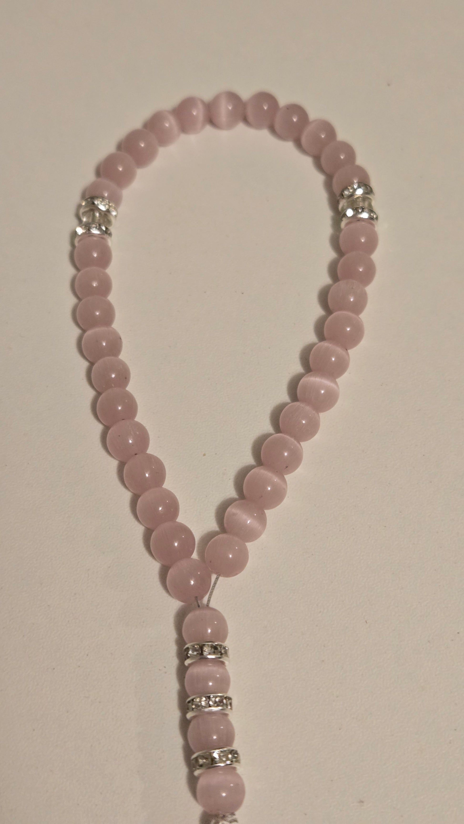 Artisan-crafted blush pink masbaha, highlighting the quality of the beads and silver details