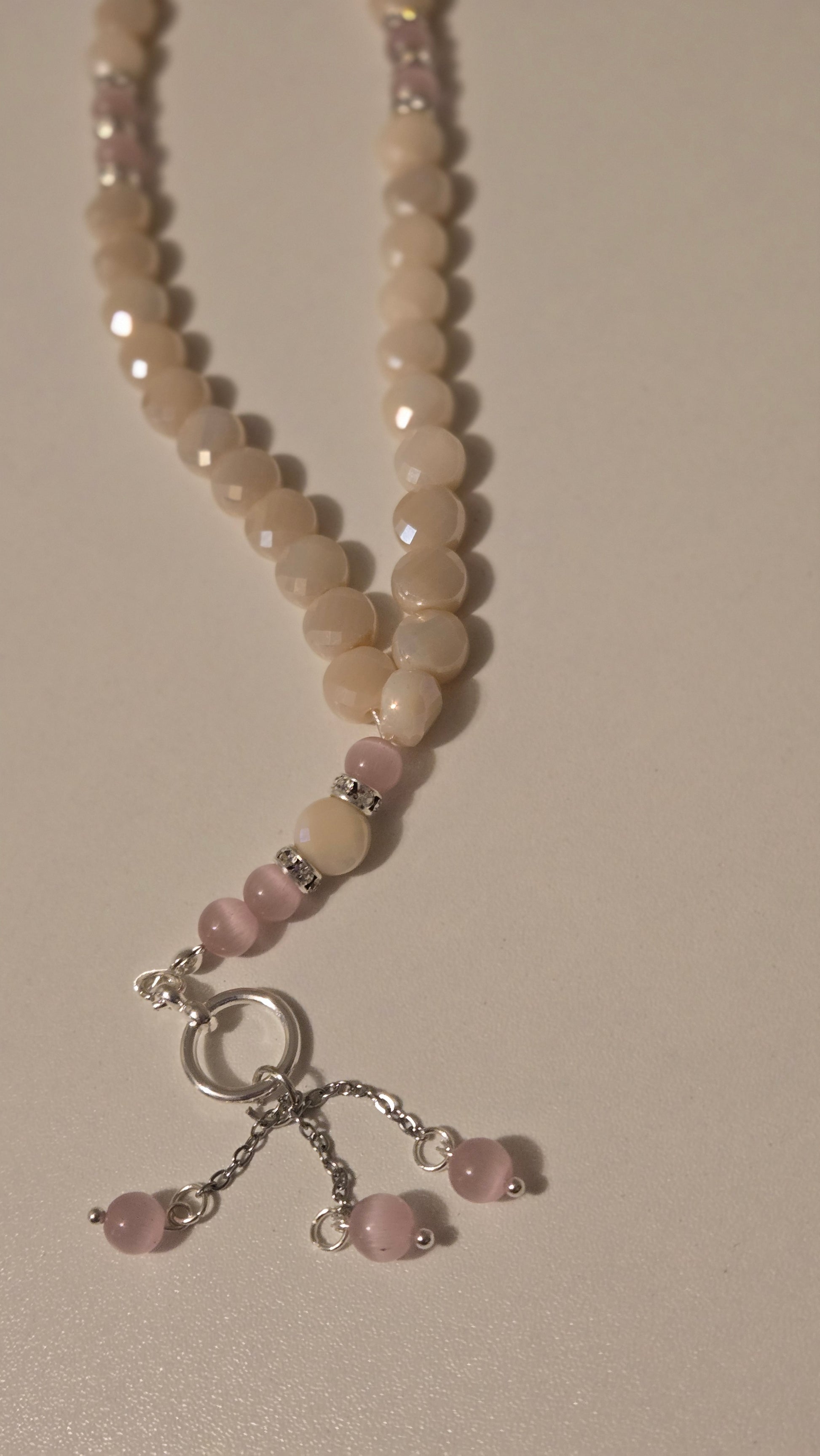 Rose Light Tasbih laid out on a soft fabric background