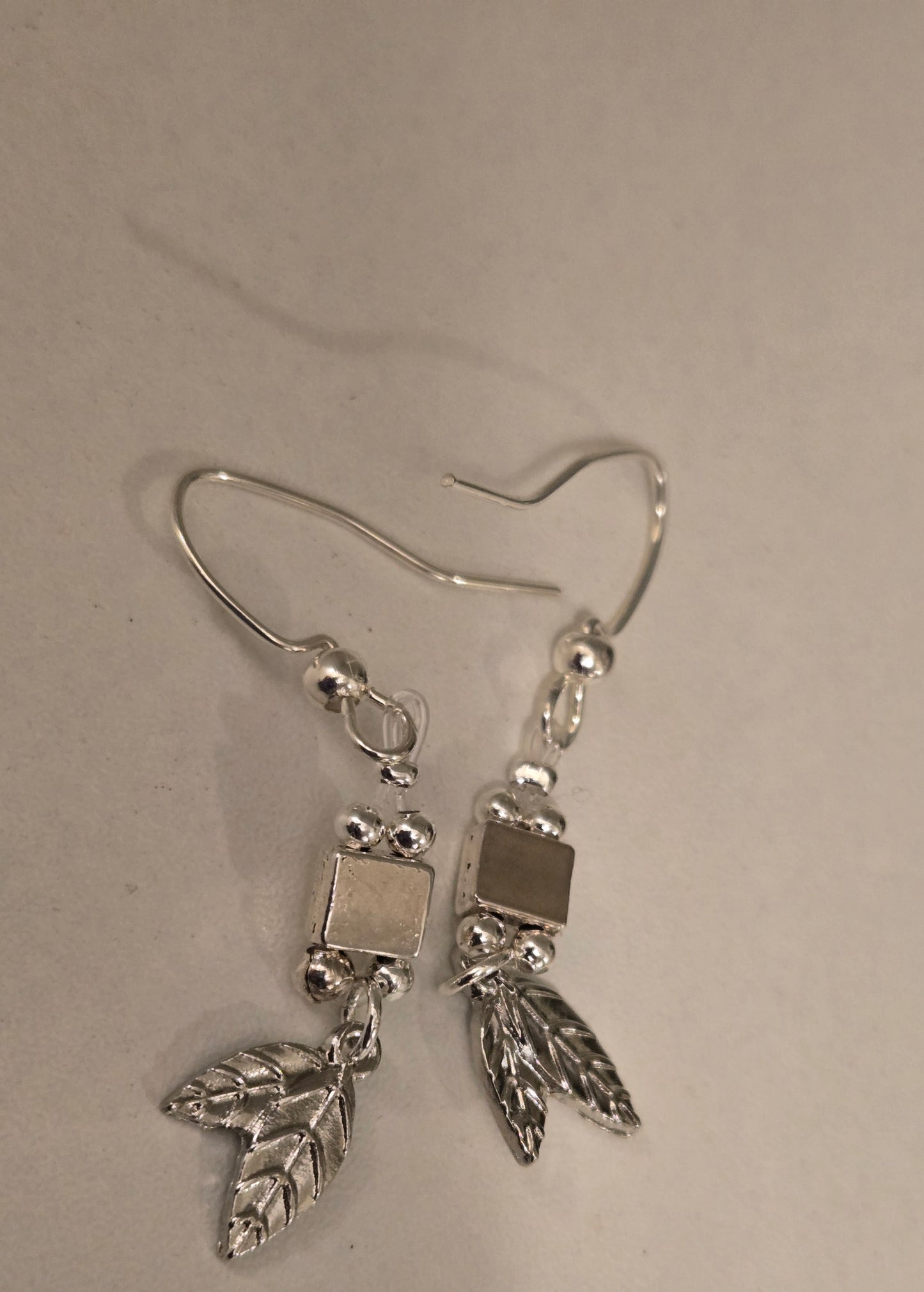 Pair of Silver Leaf Earrings on a white background, highlighting their graceful movement