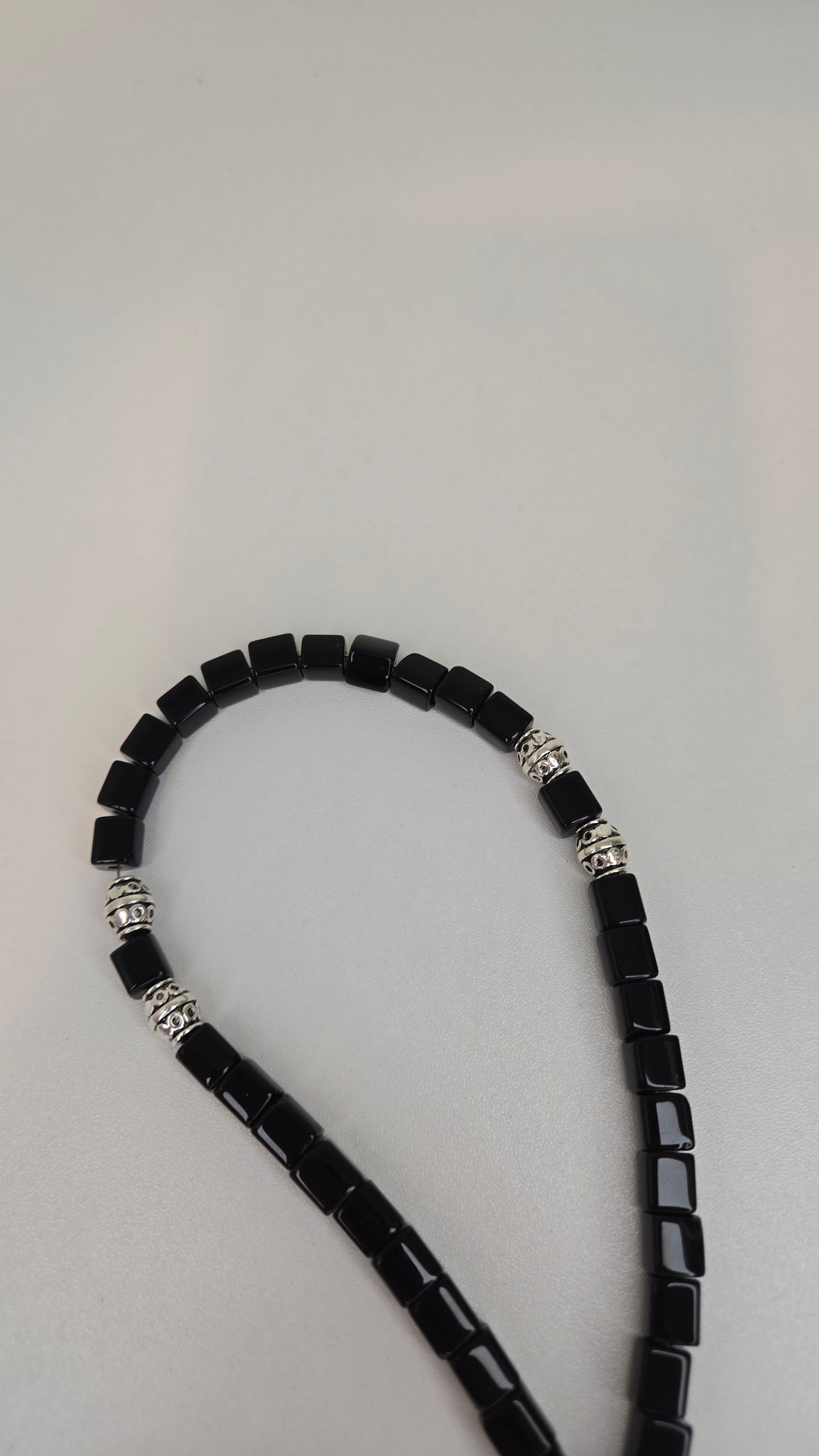 Beautifully arranged Midnight Prestige Tasbih on a soft fabric background