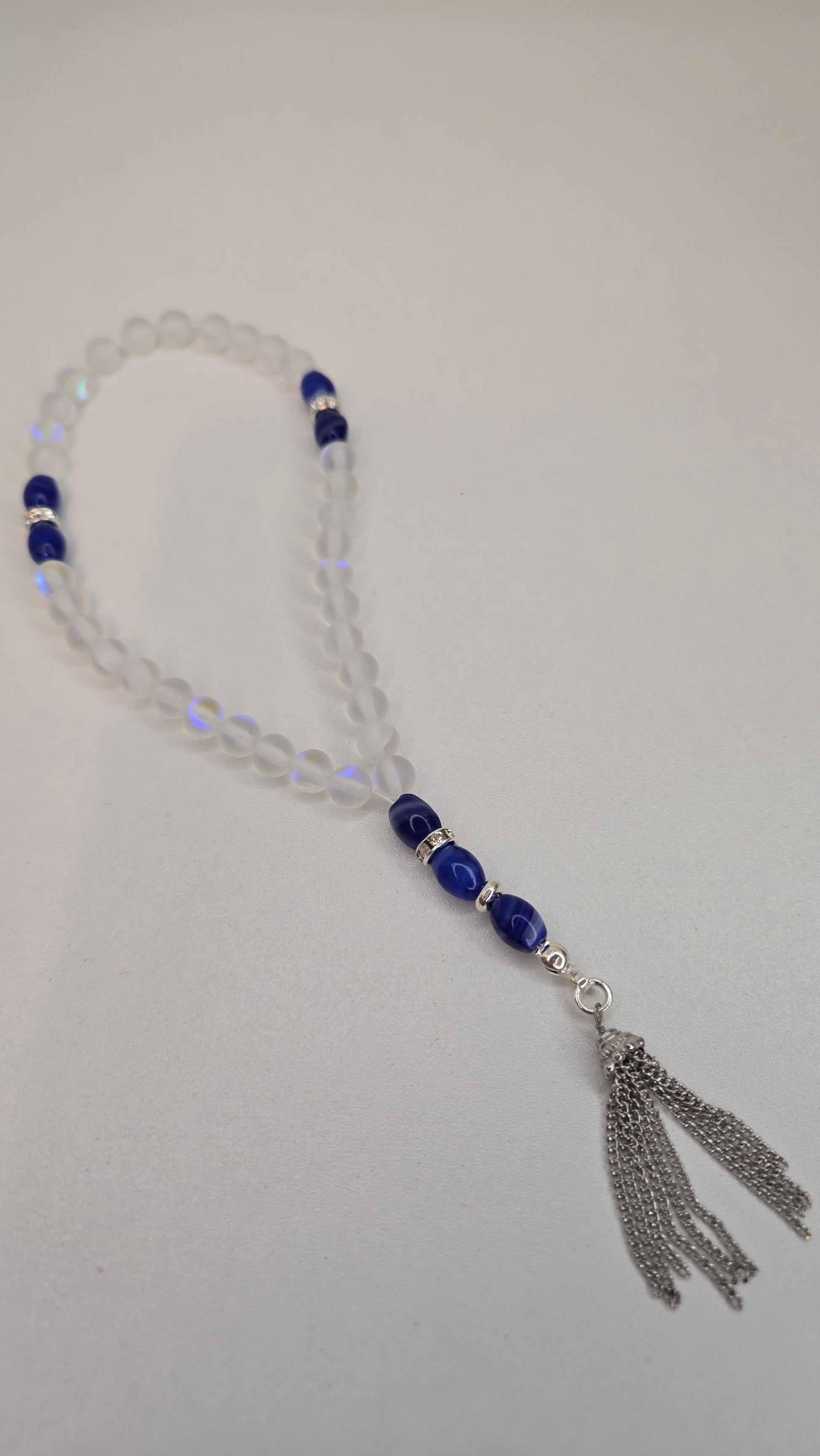 Close-up of Crystal Serenity Tasbih clear glass beads with blue accents