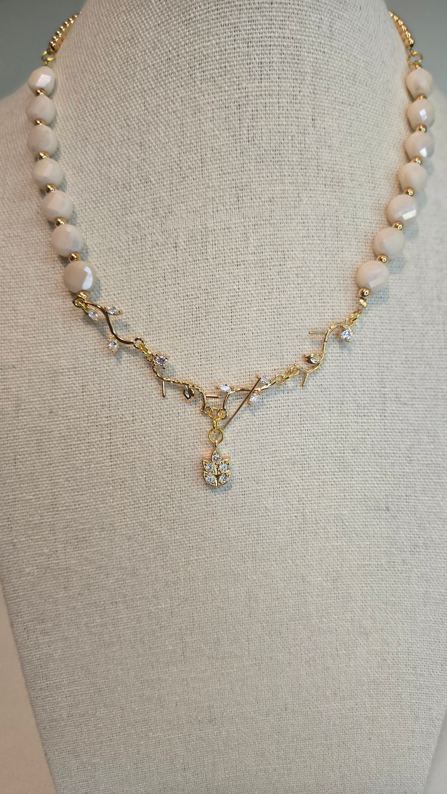 Hand holding the Elegant Pearl Branch Necklace, showing scale
