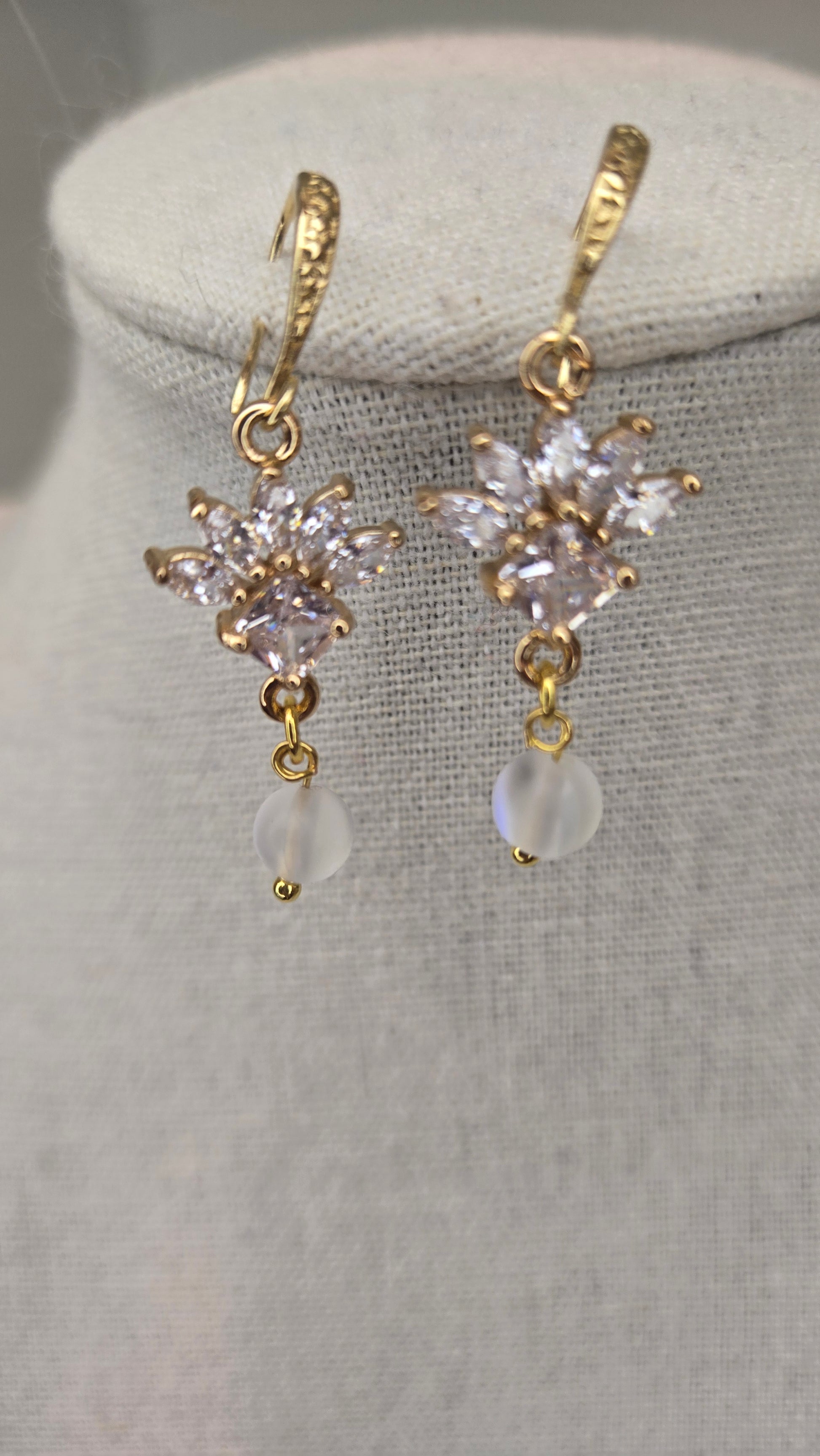 Model wearing elegant floral earrings with clear glass bead drop