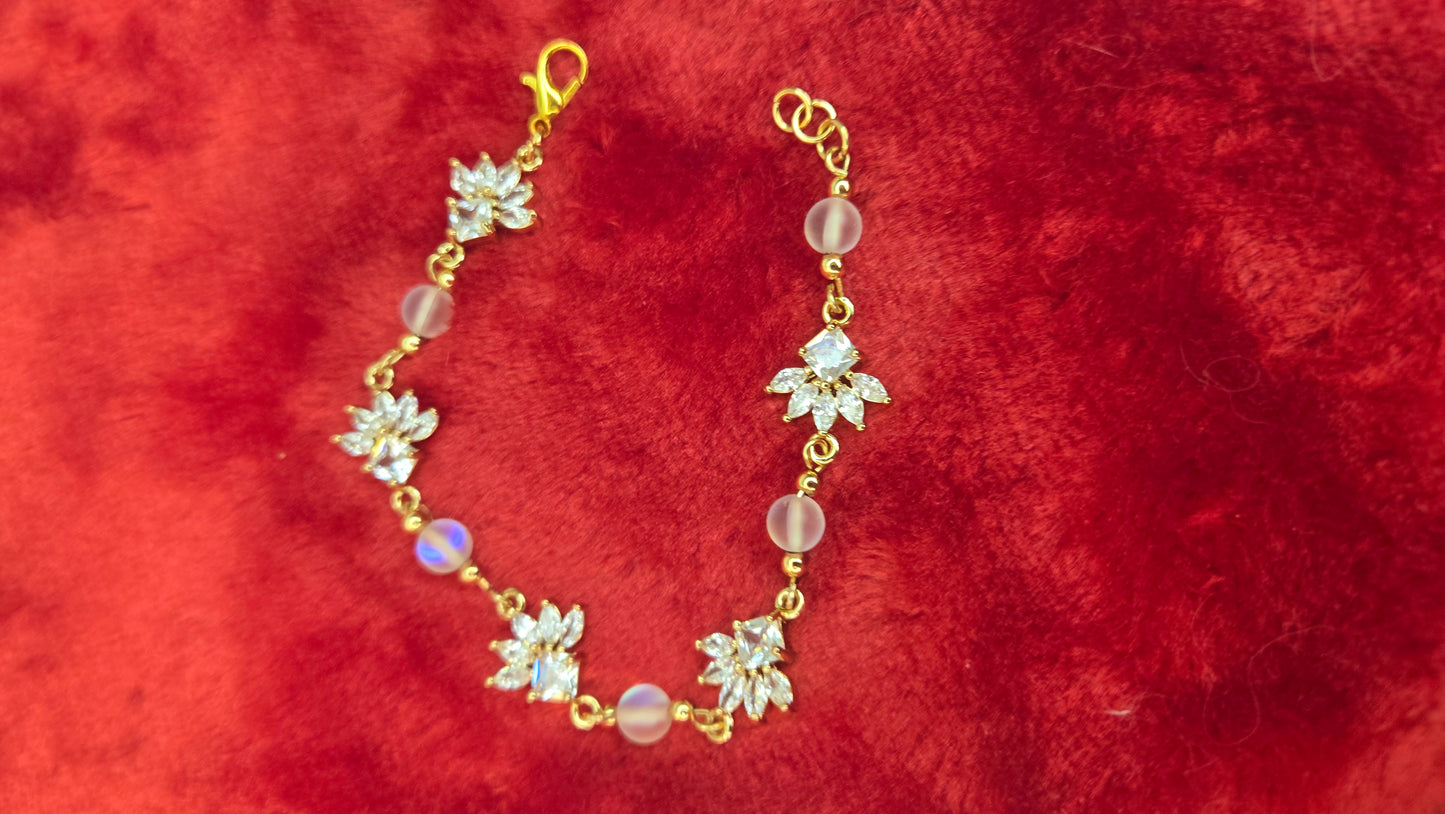Overhead view of the artisan-crafted gold-tone floral bracelet catching the light