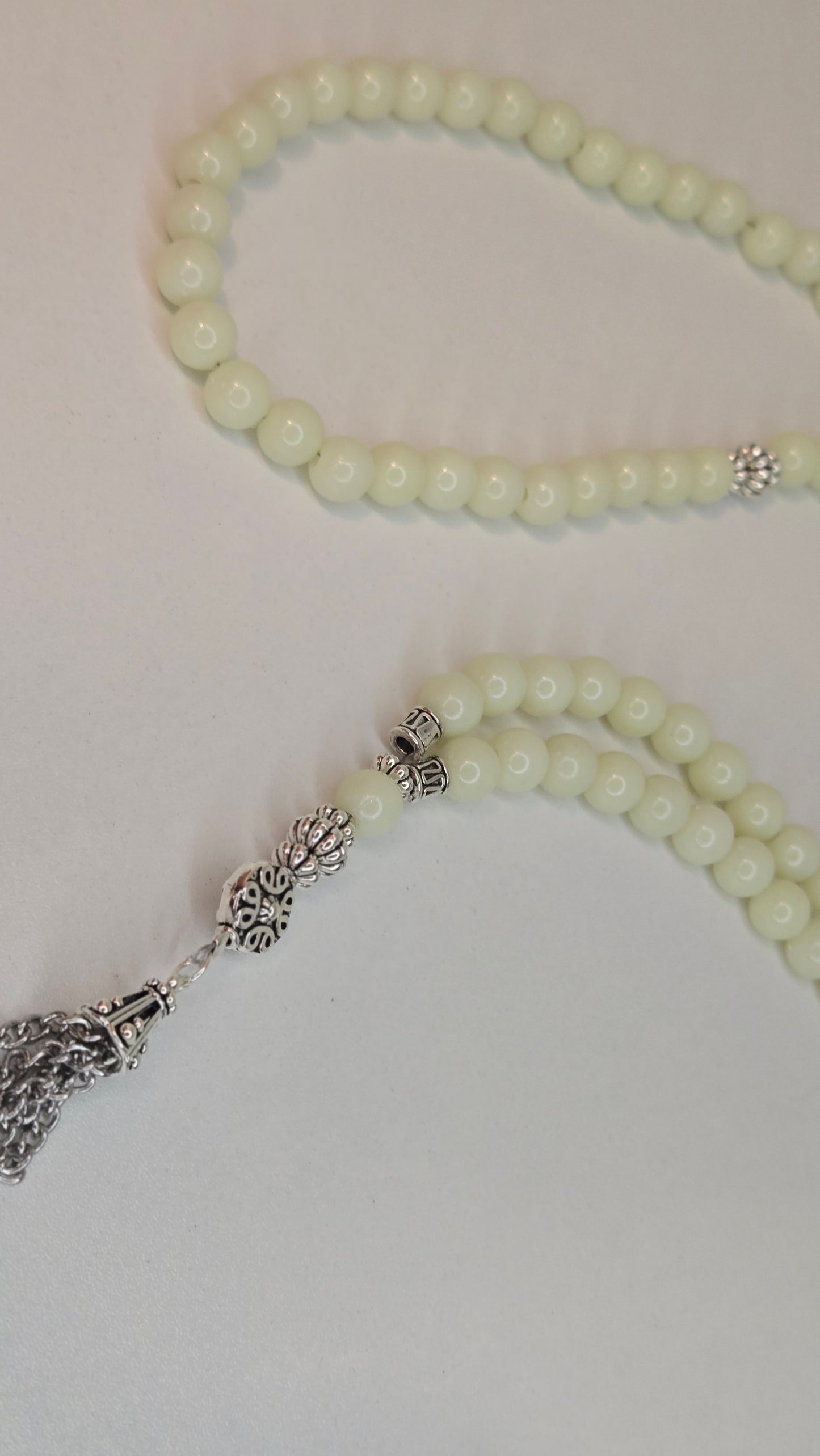 Beautiful display of Luminous Glow Prayer Beads on a wooden surface.
