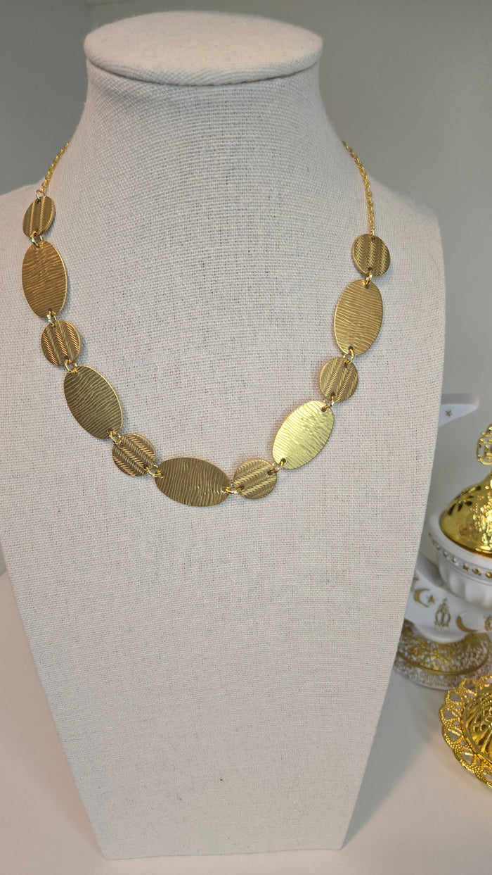 Golden Imprint Engraved Disc Necklace with an oval disc pendant on a gold-tone chain