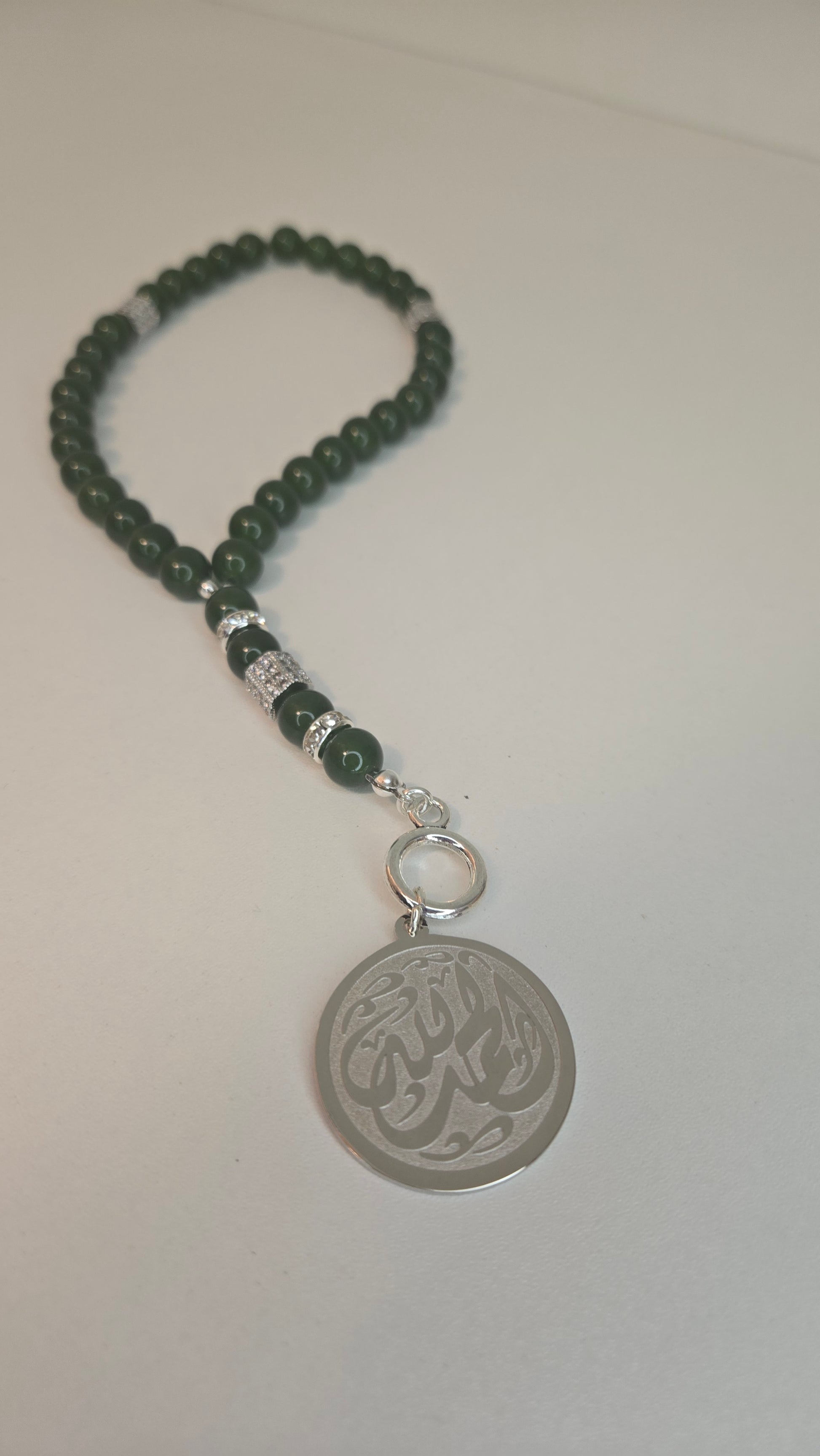 Close-up of a Blue Tiger Eye Tasbih with polished blue and teal beads and a silver accent pendant, showcasing its natural gemstone beauty.