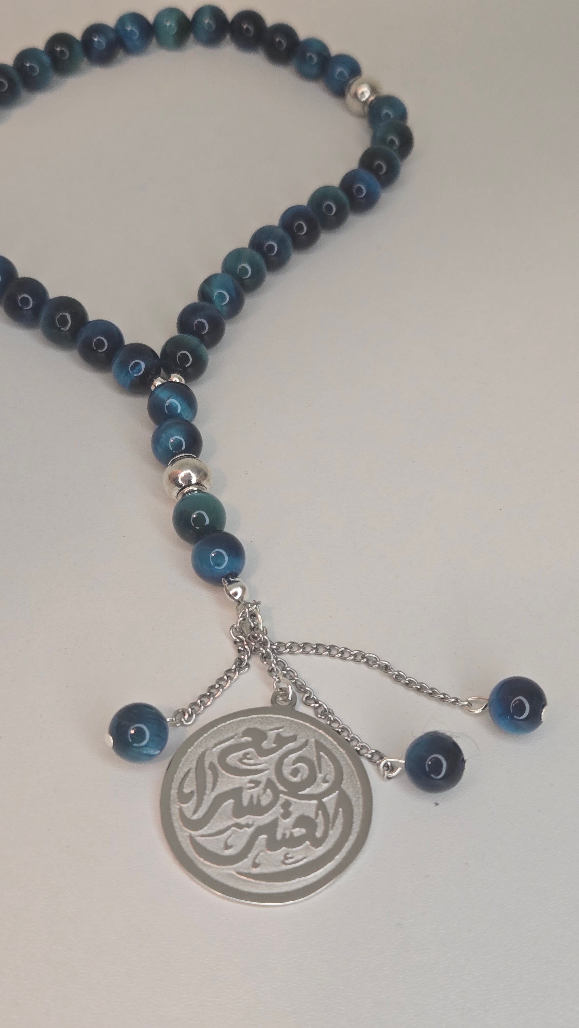 A hand holding a Blue Tiger Eye Tasbih, demonstrating its comfortable feel and versatile wear as a bracelet or accessory.