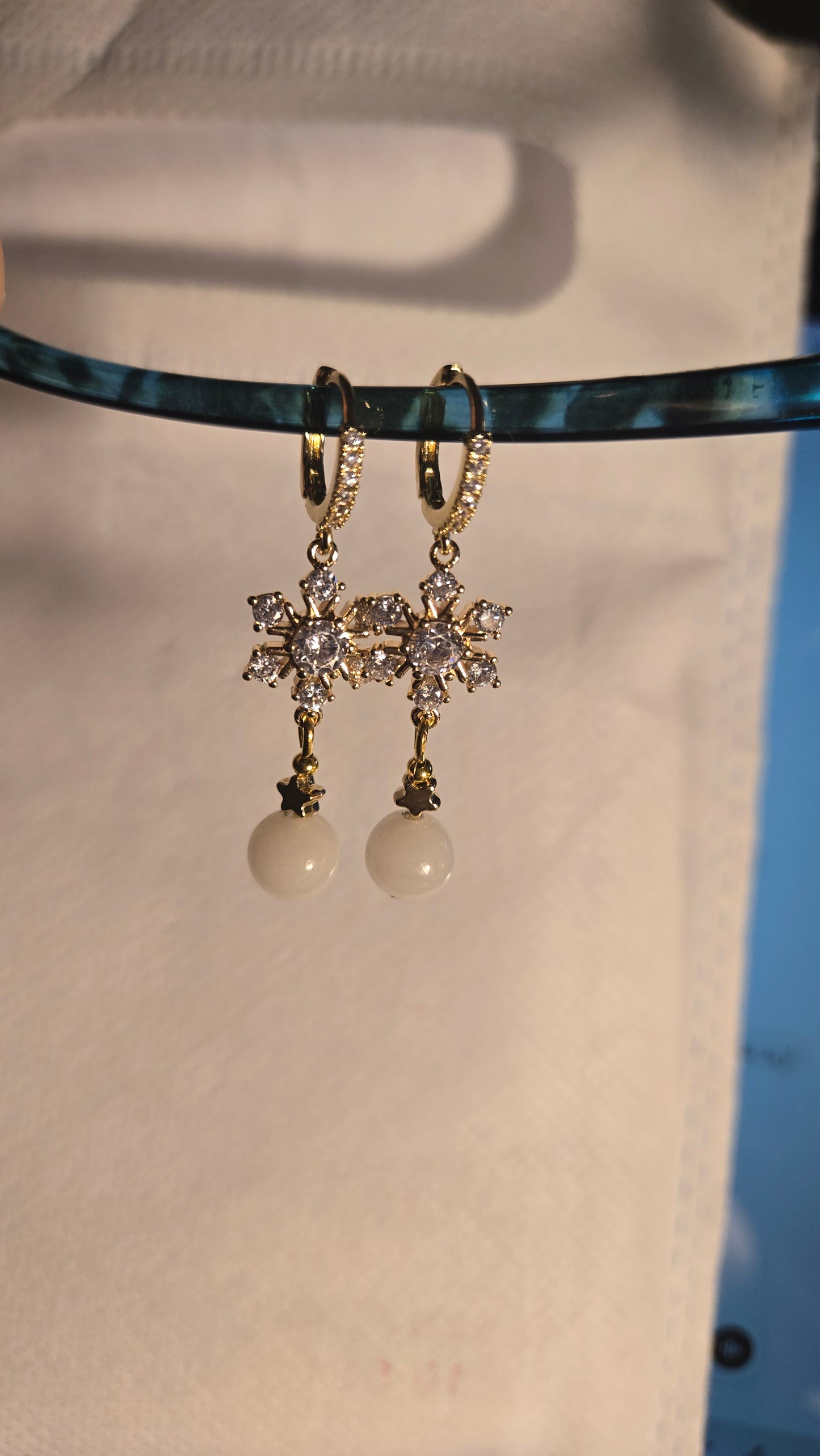 Close-up of Celestial Pearl Star Earrings, highlighting the iridescent pearl and intricate star design