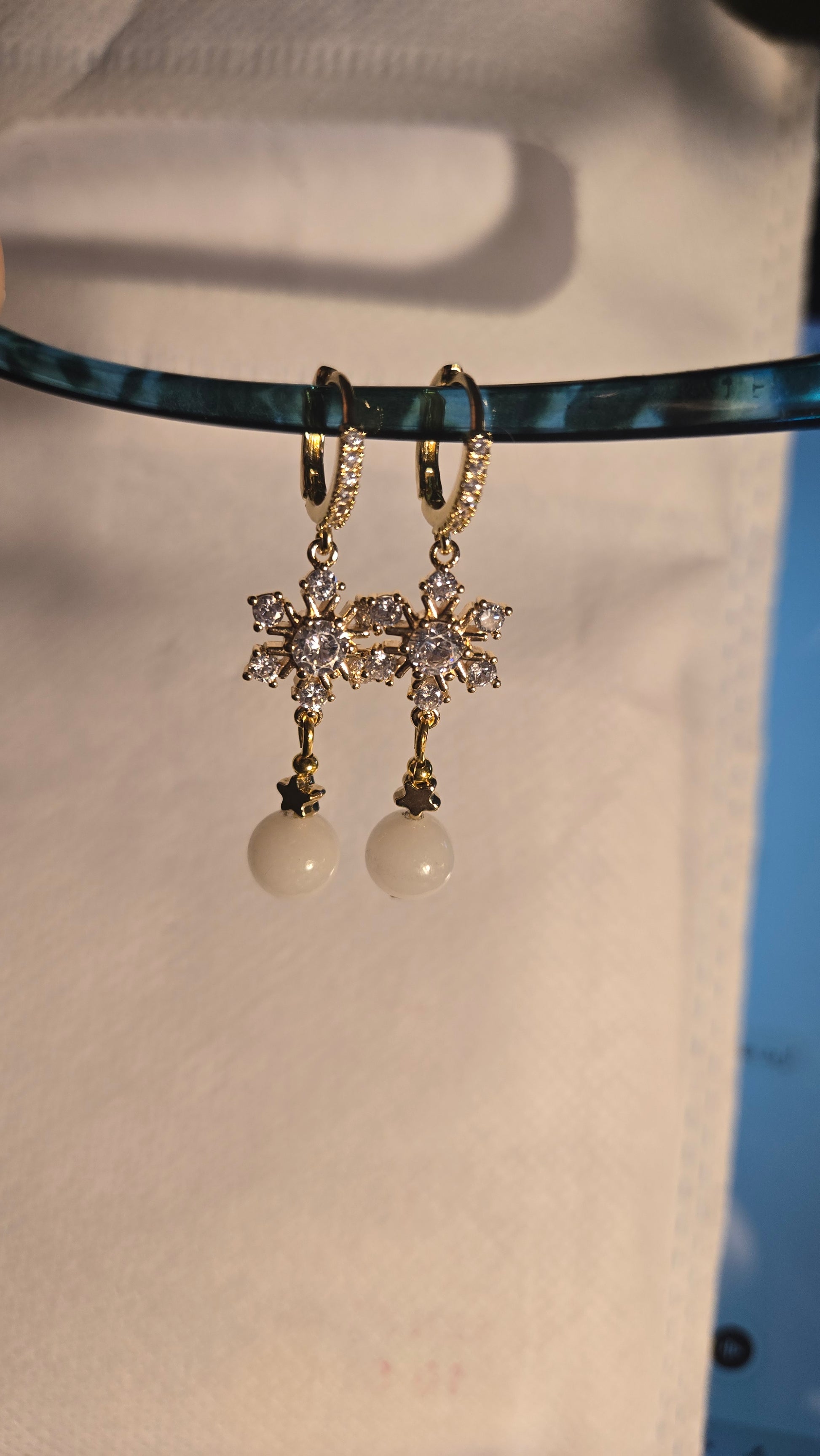 Close-up of Celestial Pearl Star Earrings, highlighting the iridescent pearl and intricate star design