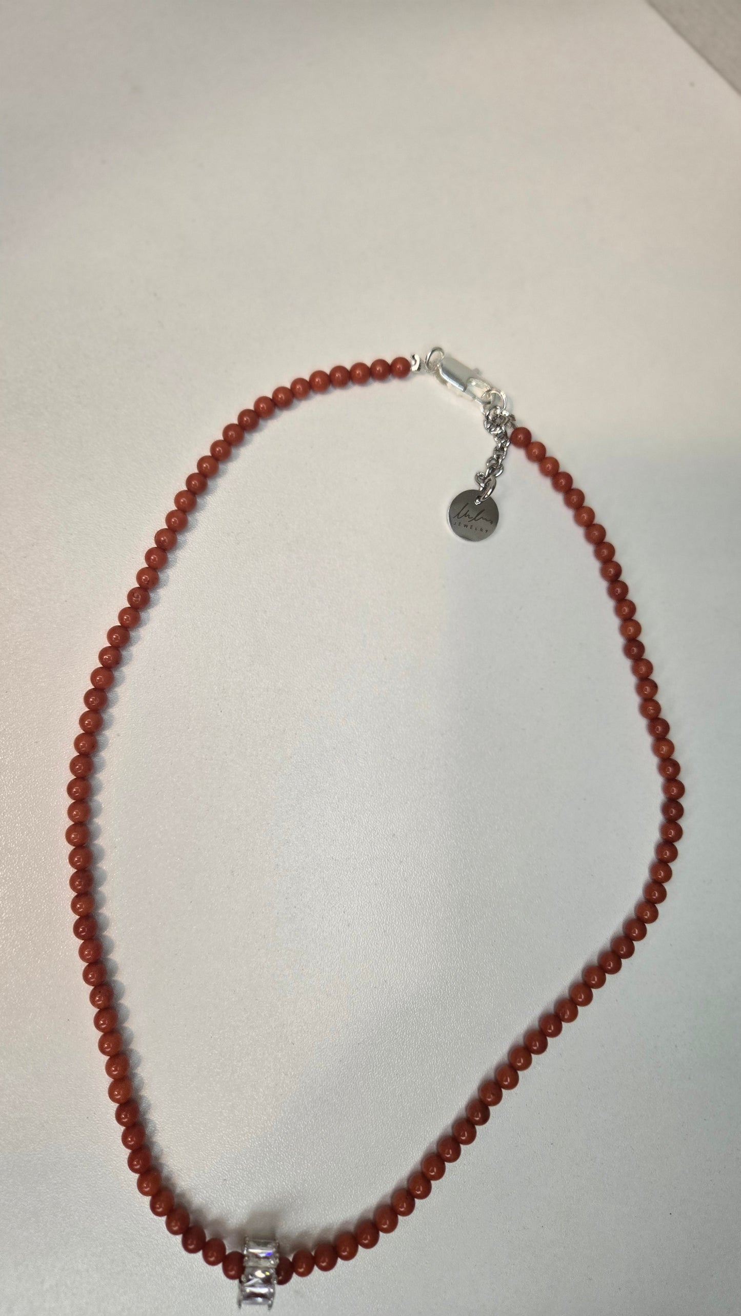Detail shot of the gold clasp and natural tiger eye stone patterns on the bracelet.