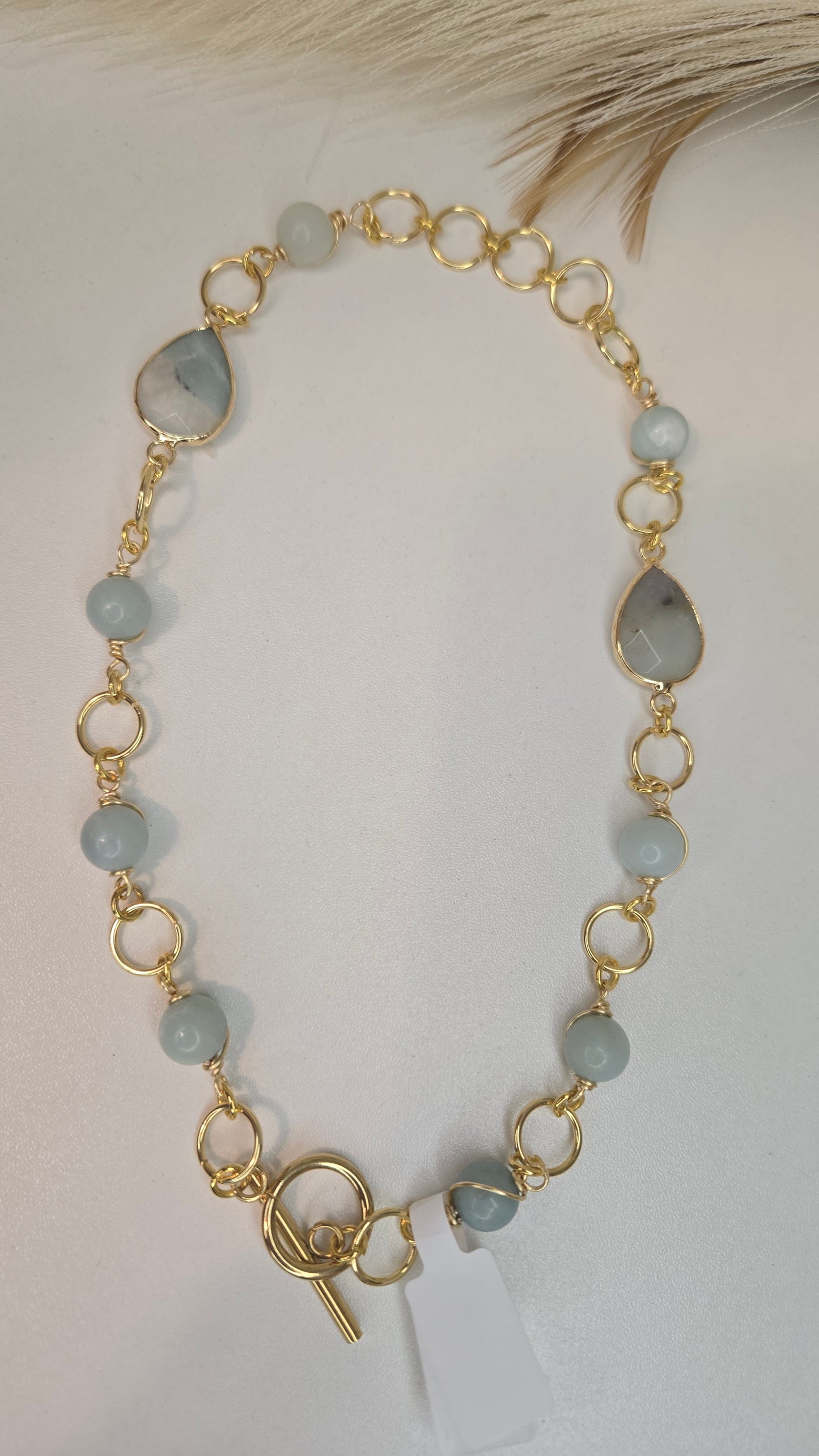 Macro view of a single amazonite bead from the necklace, showing its natural color variations and smooth polish.