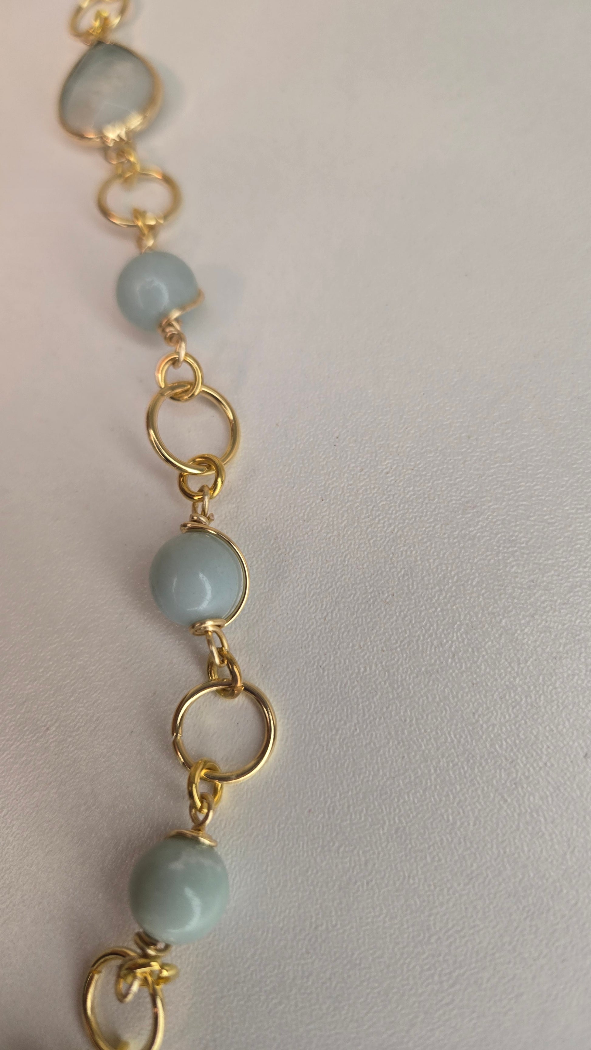 Lifestyle shot of the Amazonite & Agate Necklace alongside other complementary gold jewelry, suggesting styling options.