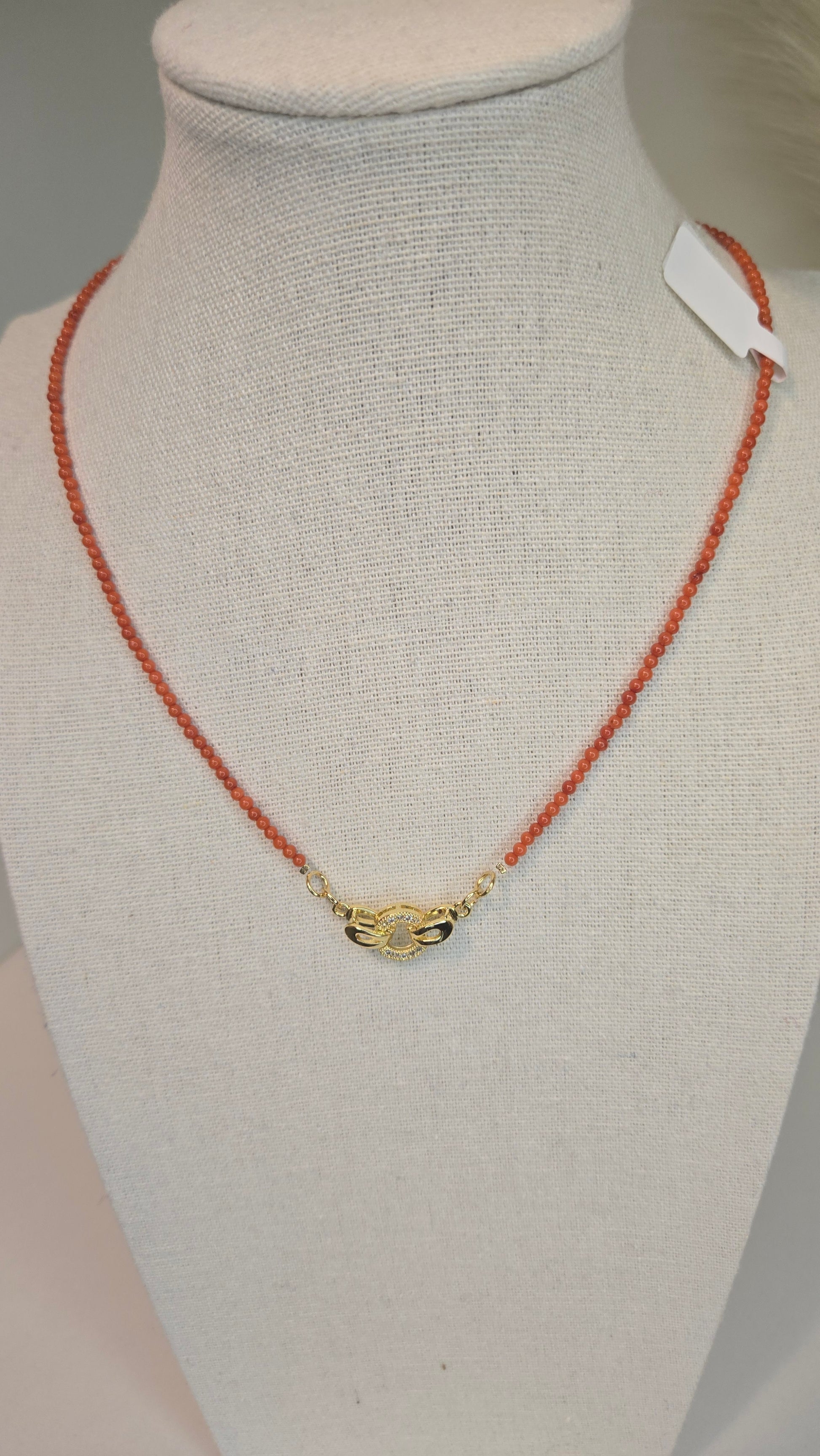 Lifestyle shot of Coral Whisper Necklace on a neutral background, emphasizing its unique design