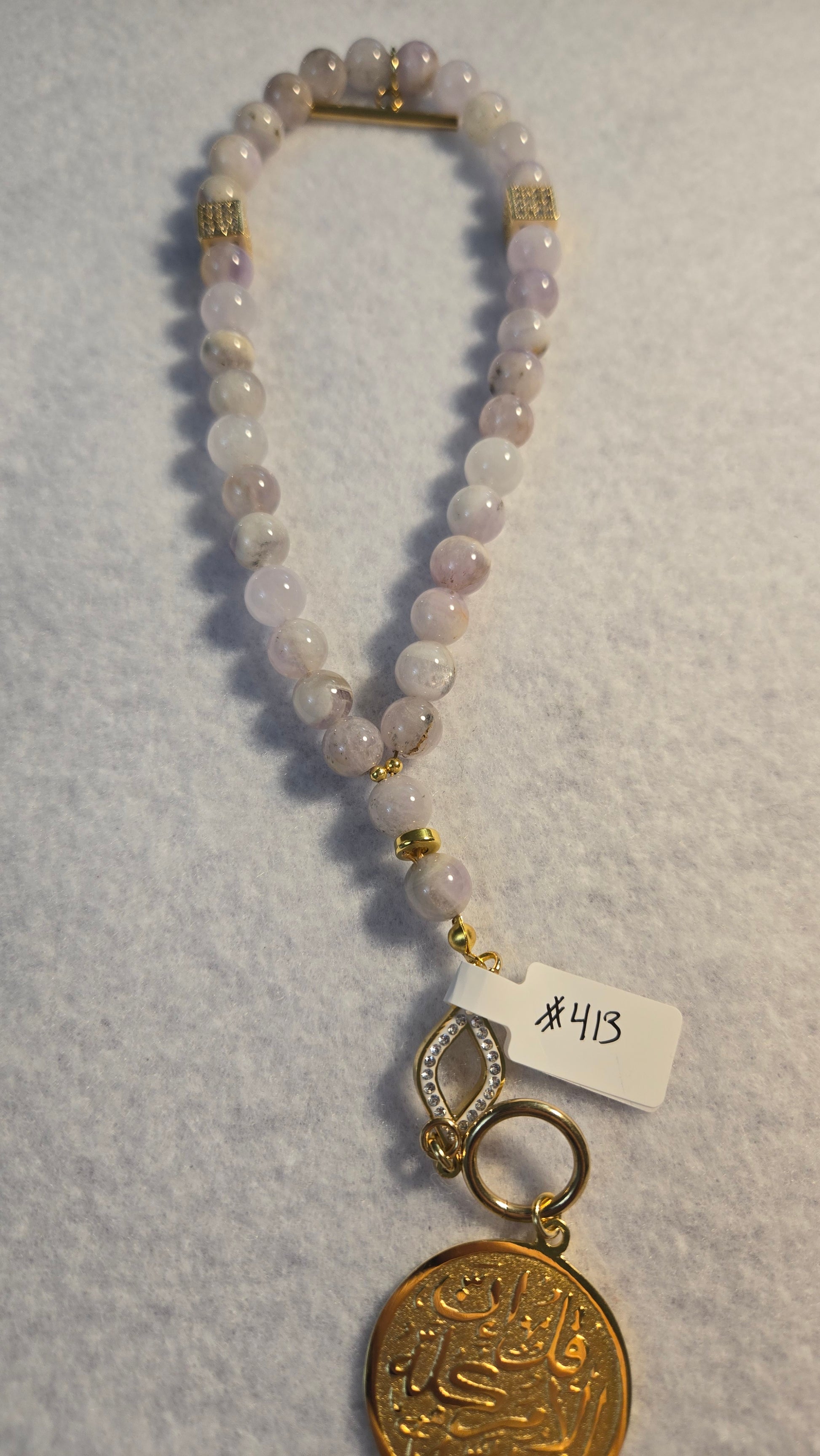 Woman wearing Amethyst Whisper Tasbih as a spiritual bracelet, close-up