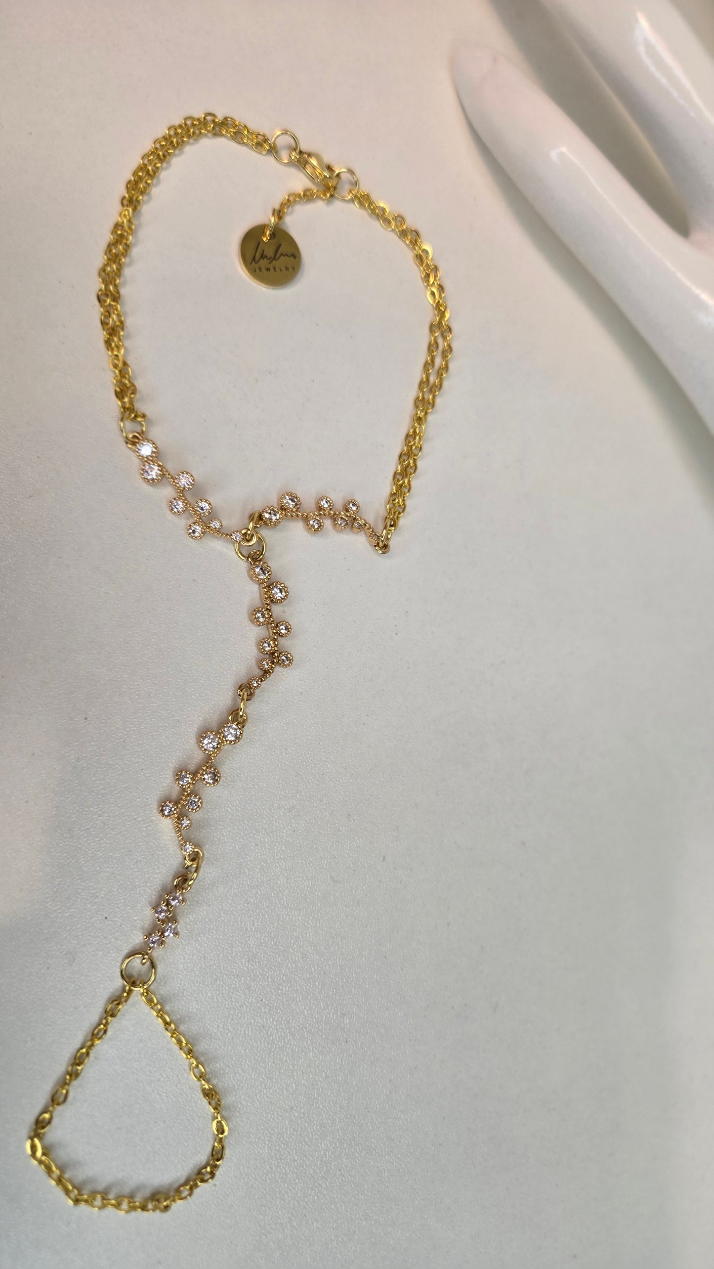Elegant Hand Chain Bracelet on a white surface, highlighting its shine