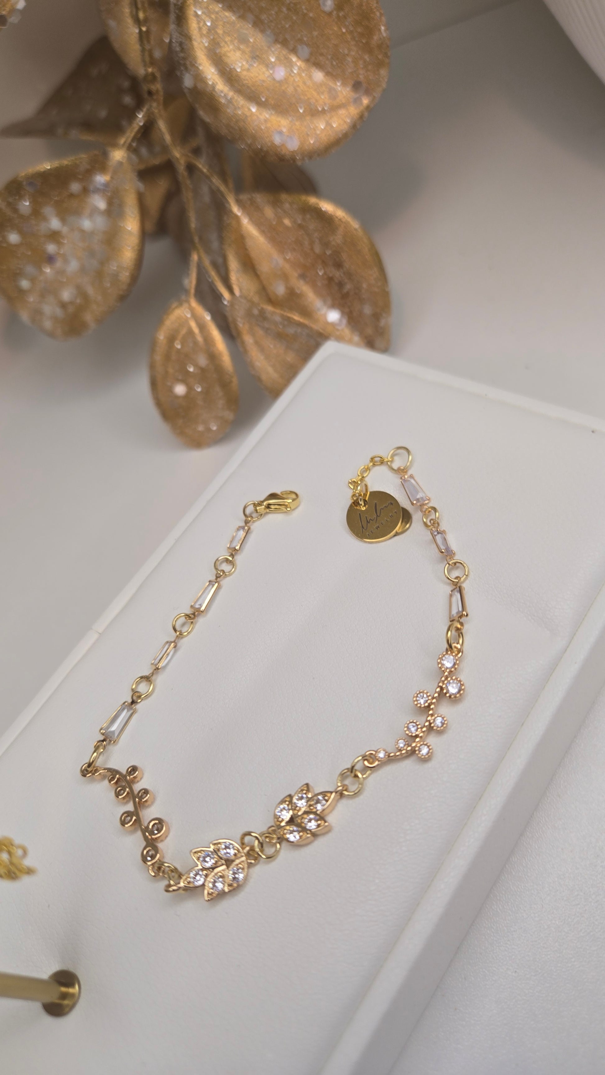 Elegant gold-tone bracelet with intricate floral details from the set