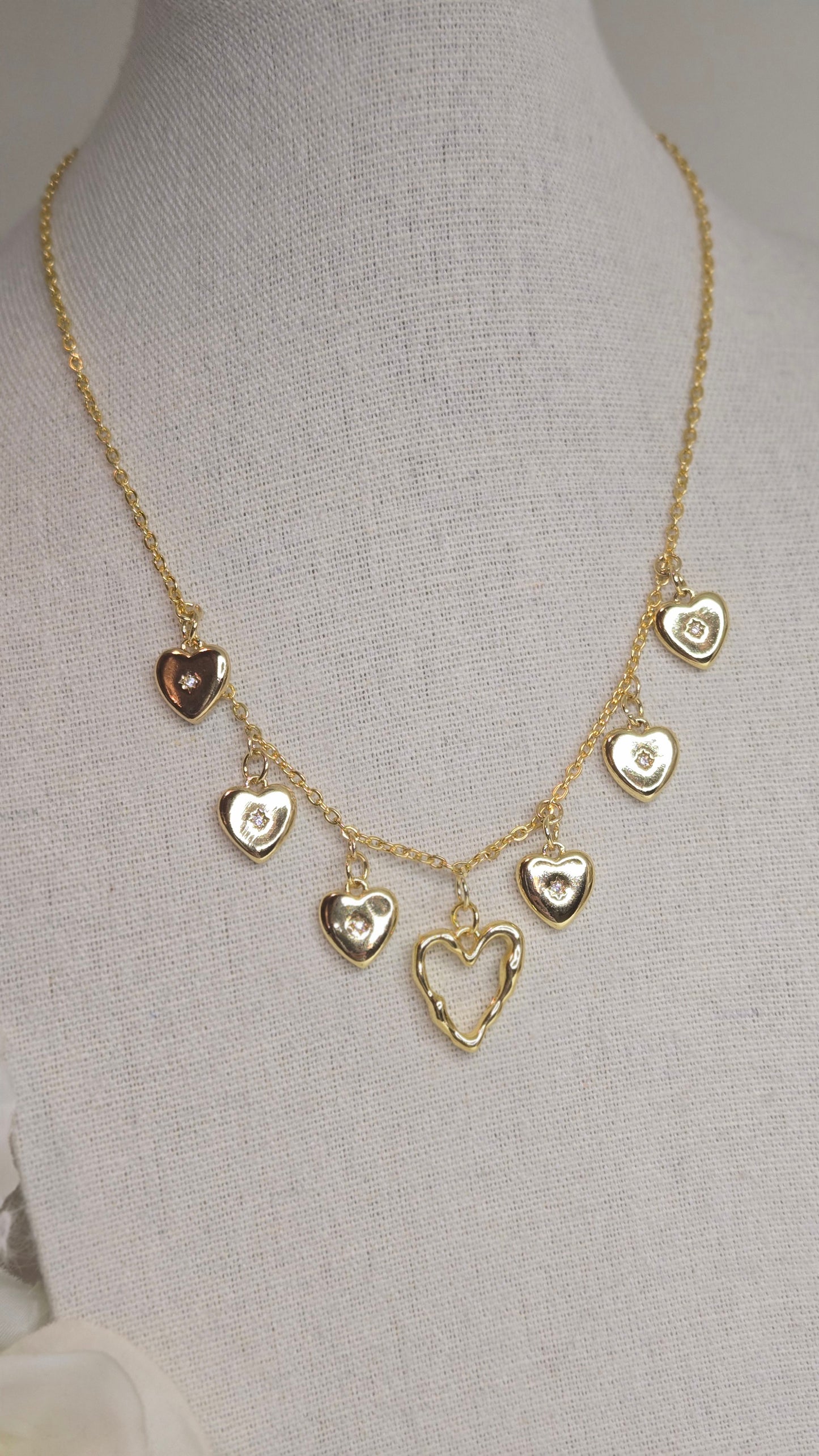 Golden Heart Charm Necklace on a soft fabric background