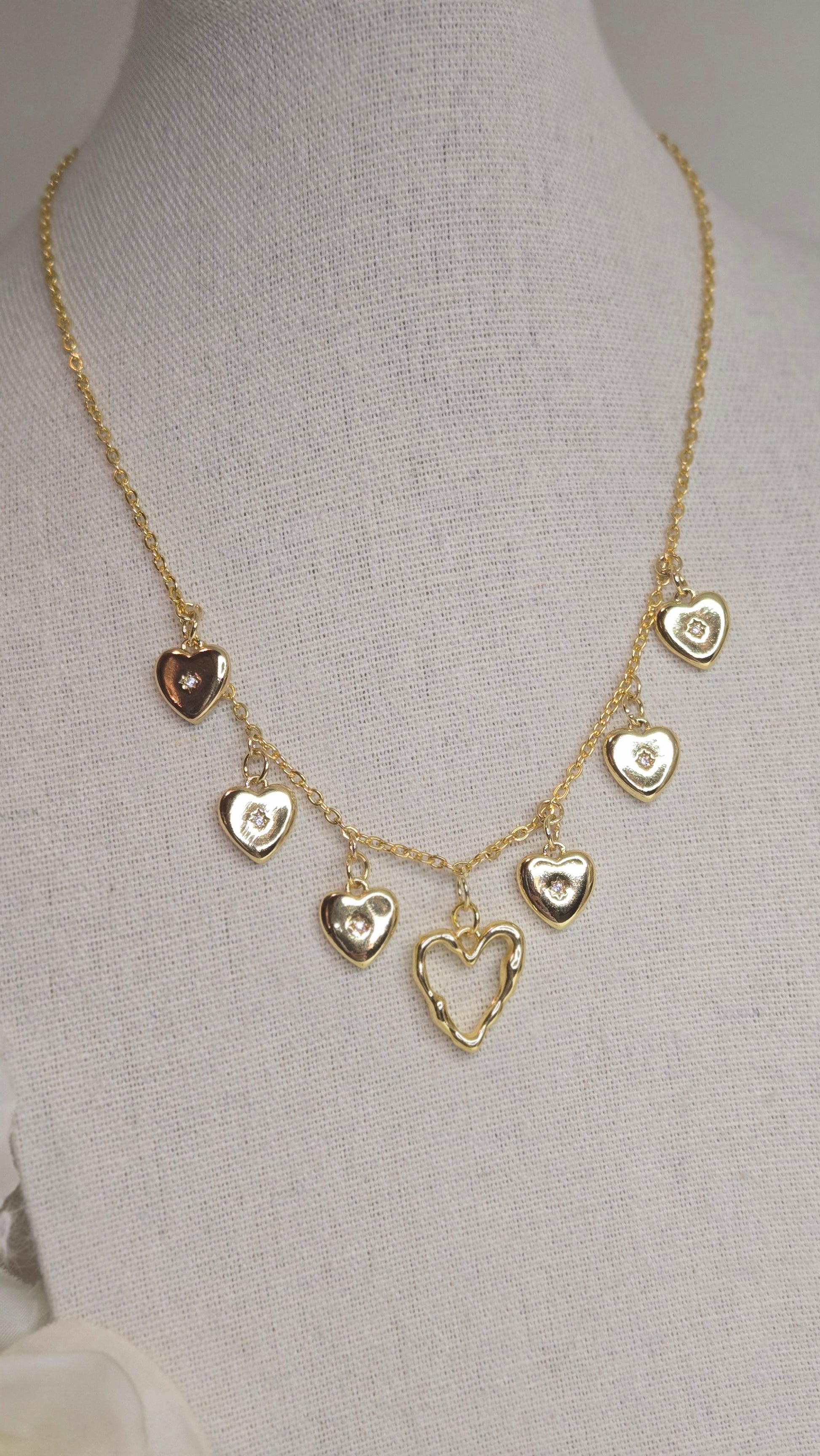 Golden Heart Charm Necklace on a soft fabric background
