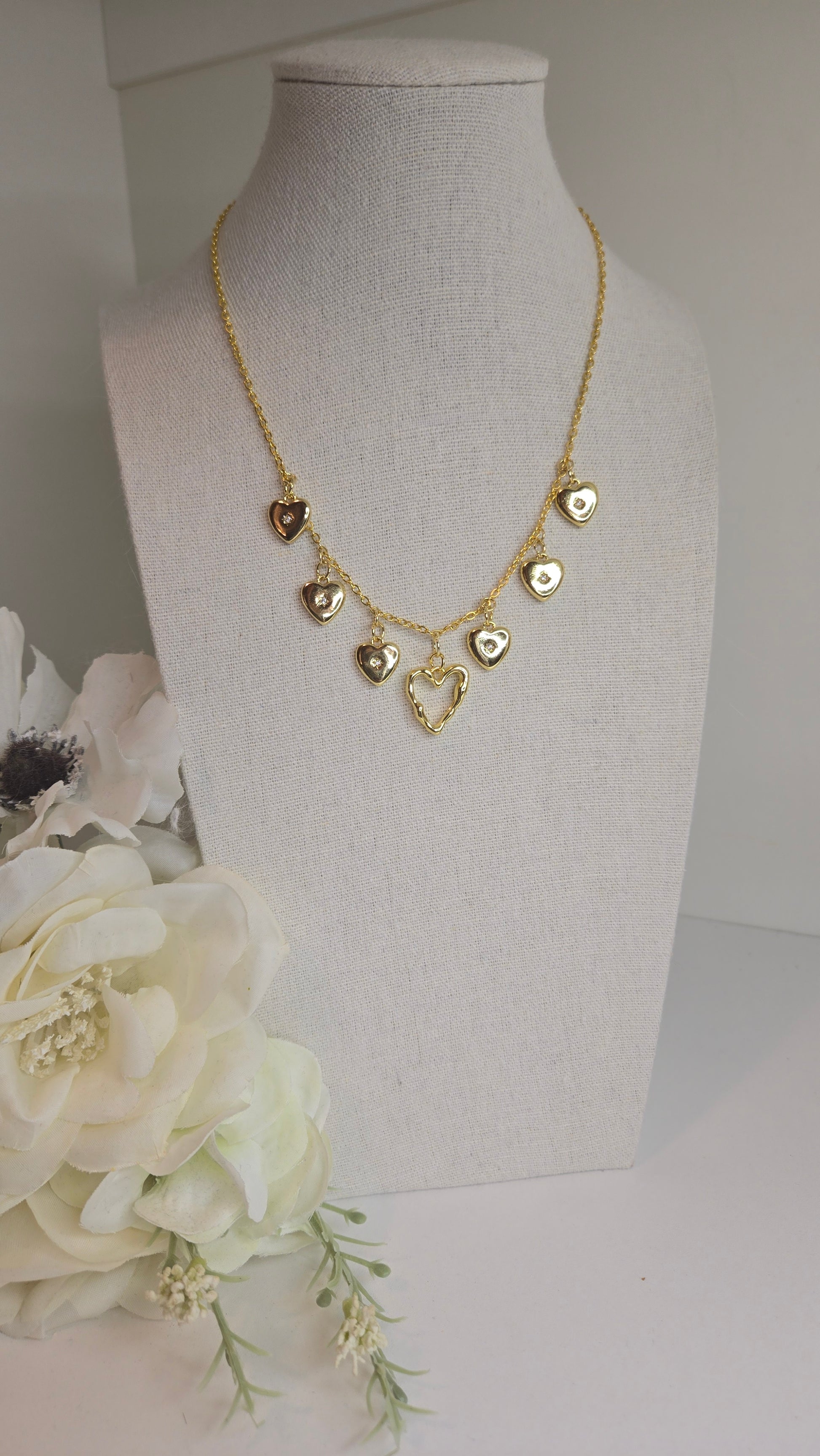 Golden Heart Charm Necklace gently resting on a marble surface