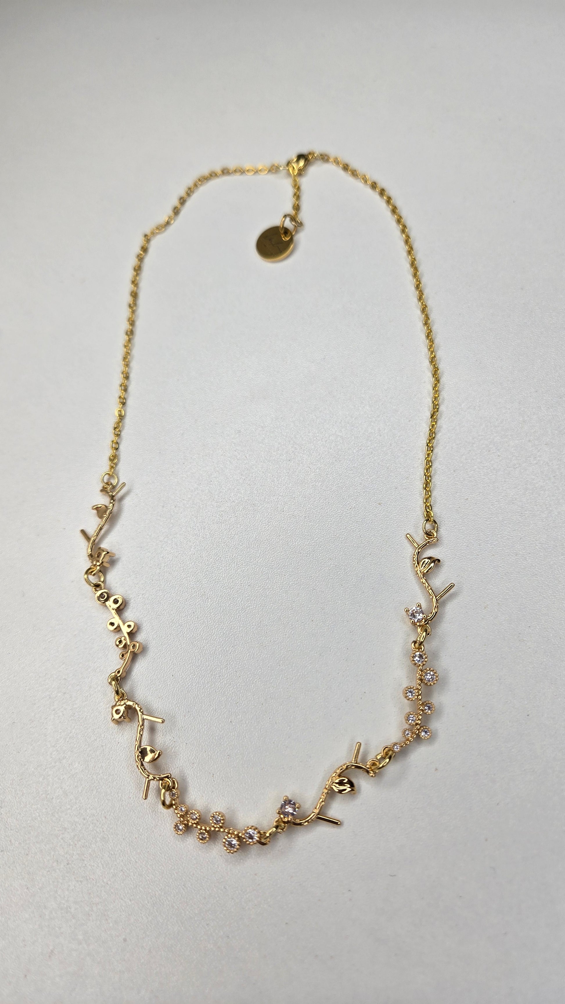 Golden Branch Necklace with glittering accents against soft fabric