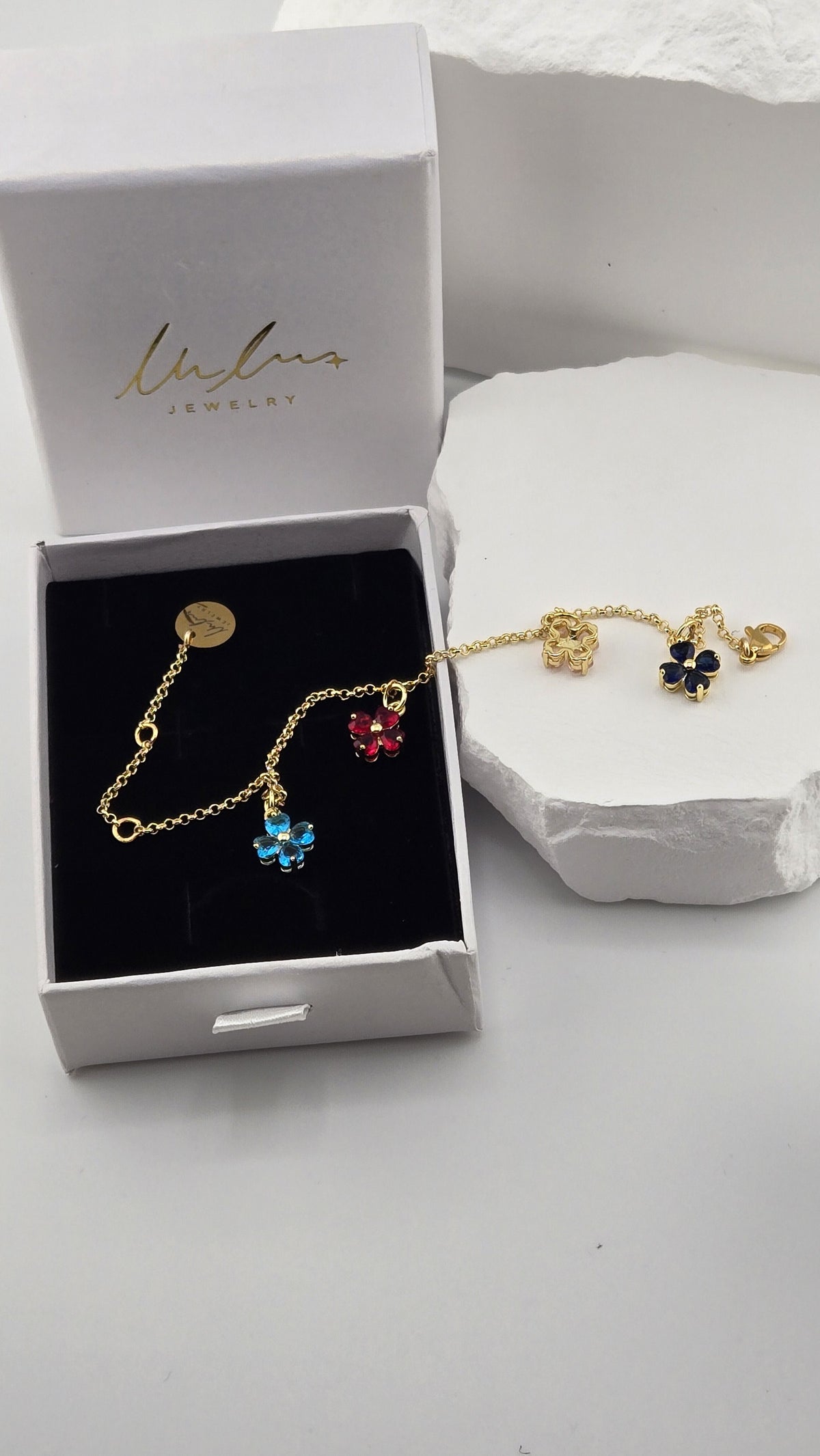 Confetti Charm Bracelet draped from a LuluTouch gift box