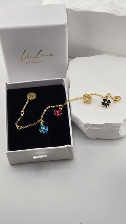 Confetti Charm Bracelet draped from a LuluTouch gift box