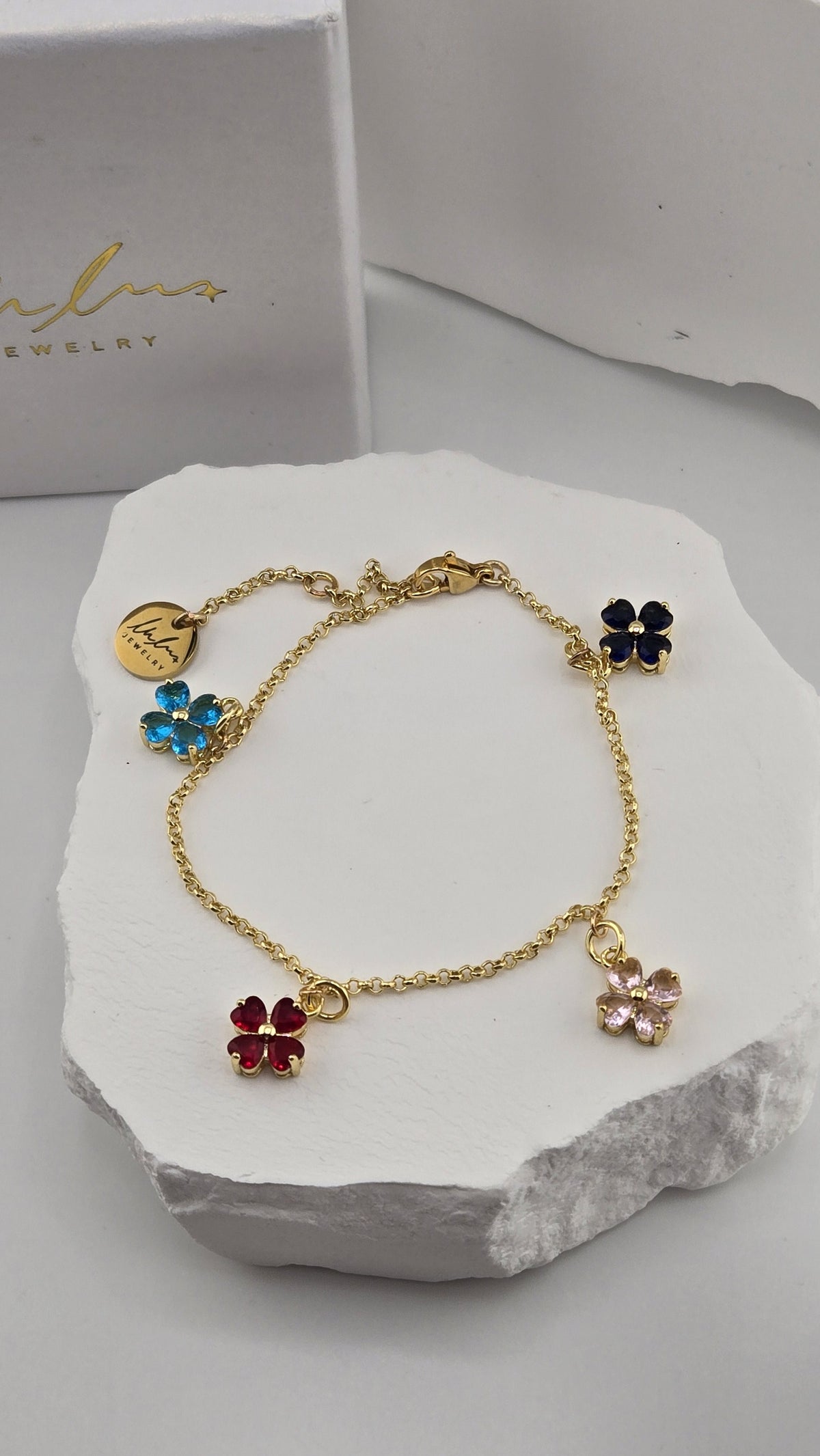 Close-up of the blue, navy, red and pink flower charms and LuluTouch tag