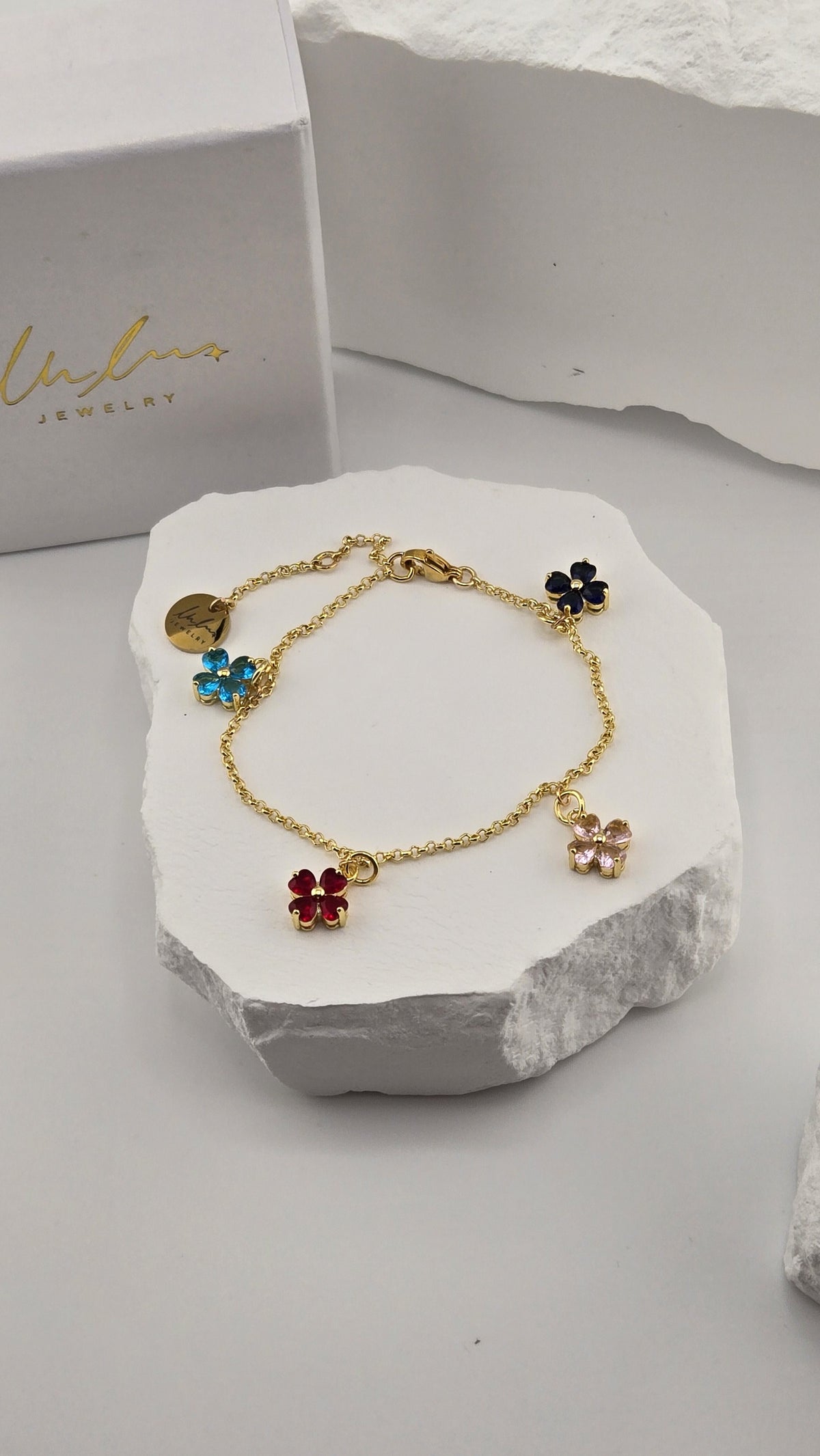 Confetti Charm Bracelet with four colorful heart-petal flower charms on a gold-plated chain