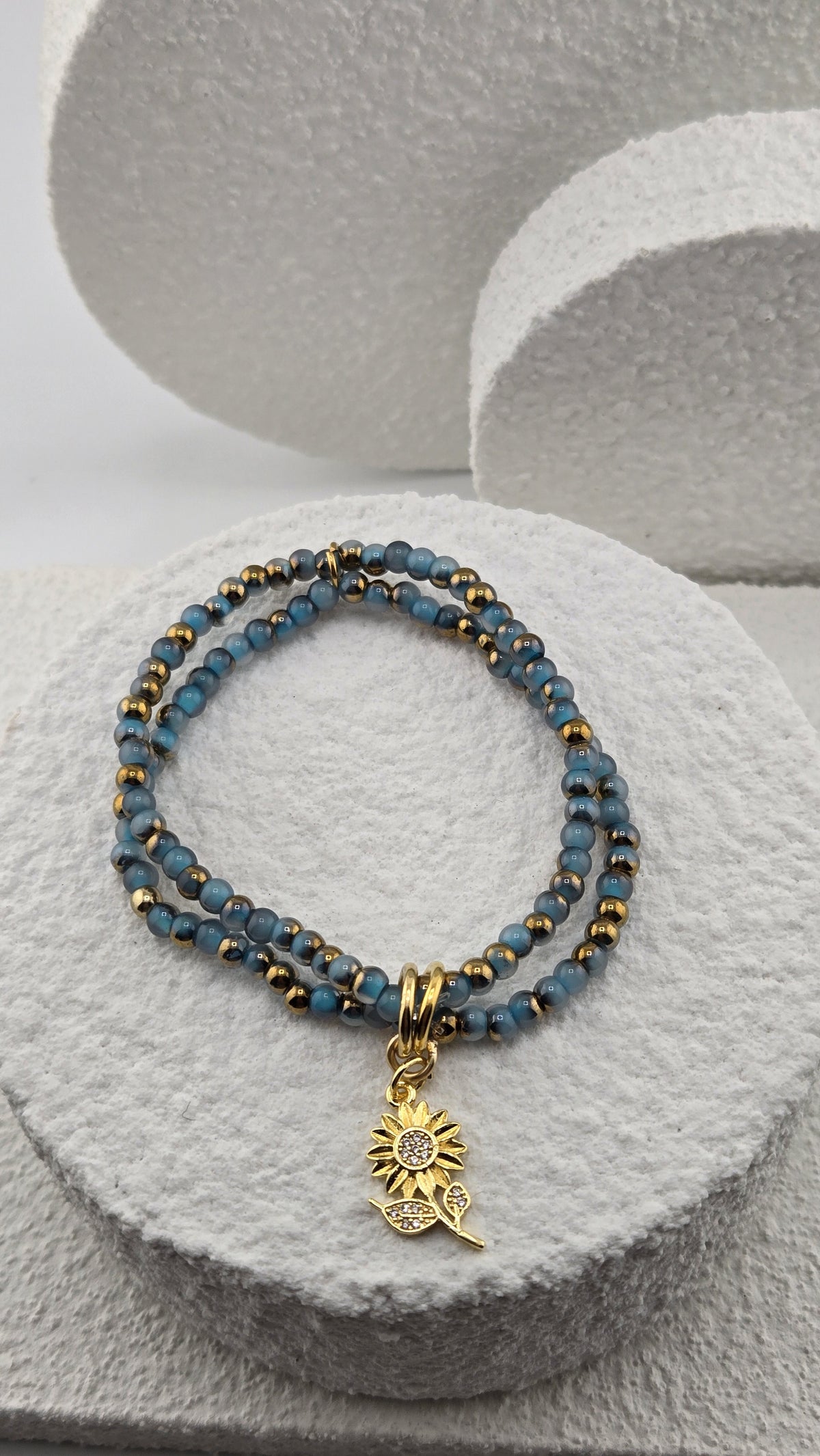 Denim Sunbeam Bracelet, two strands of blue beads with a gold-plated sunflower charm