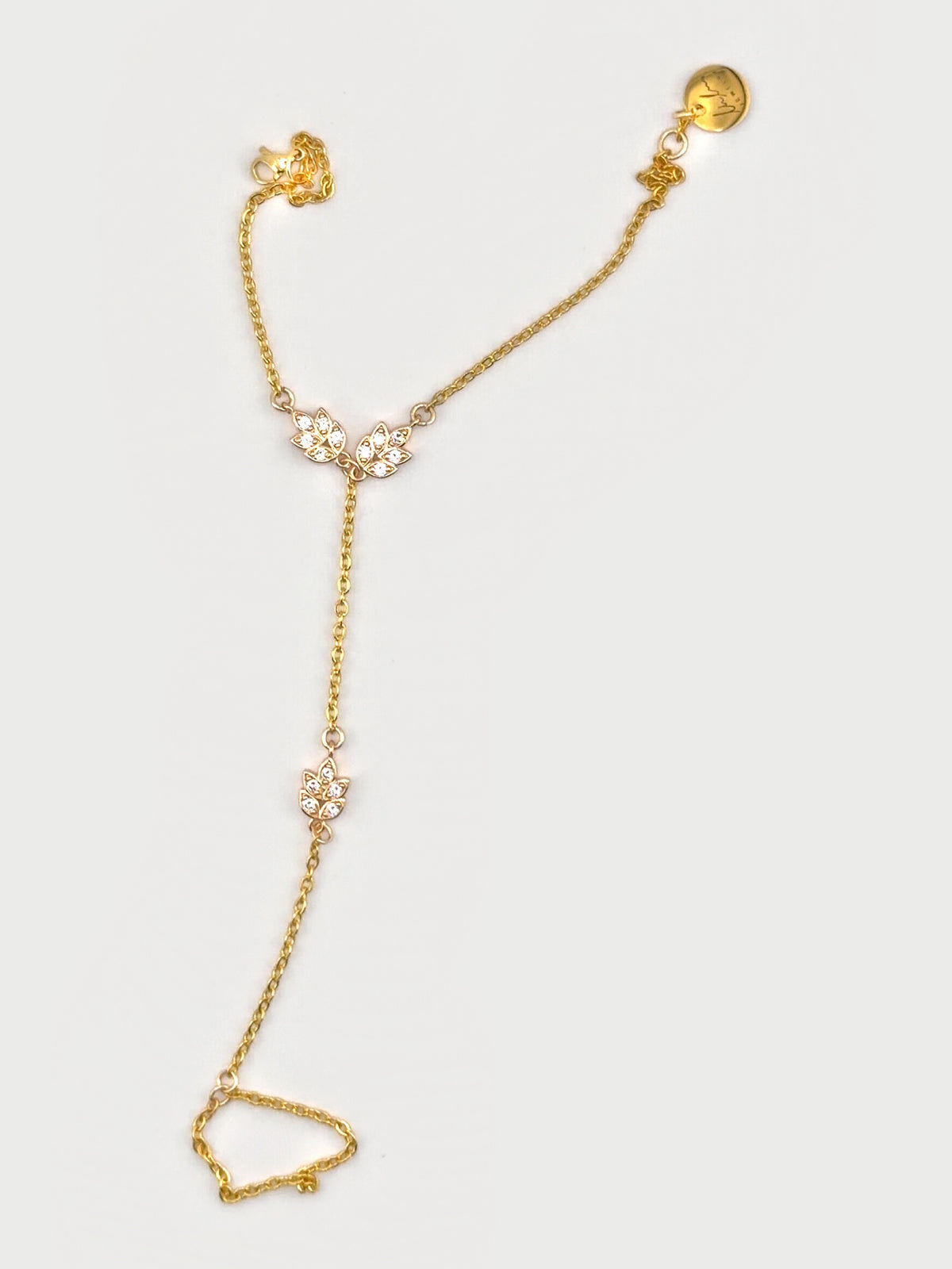 Golden Laurel Hand Chain laid flat, showing the bracelet, leaf charms and finger ring