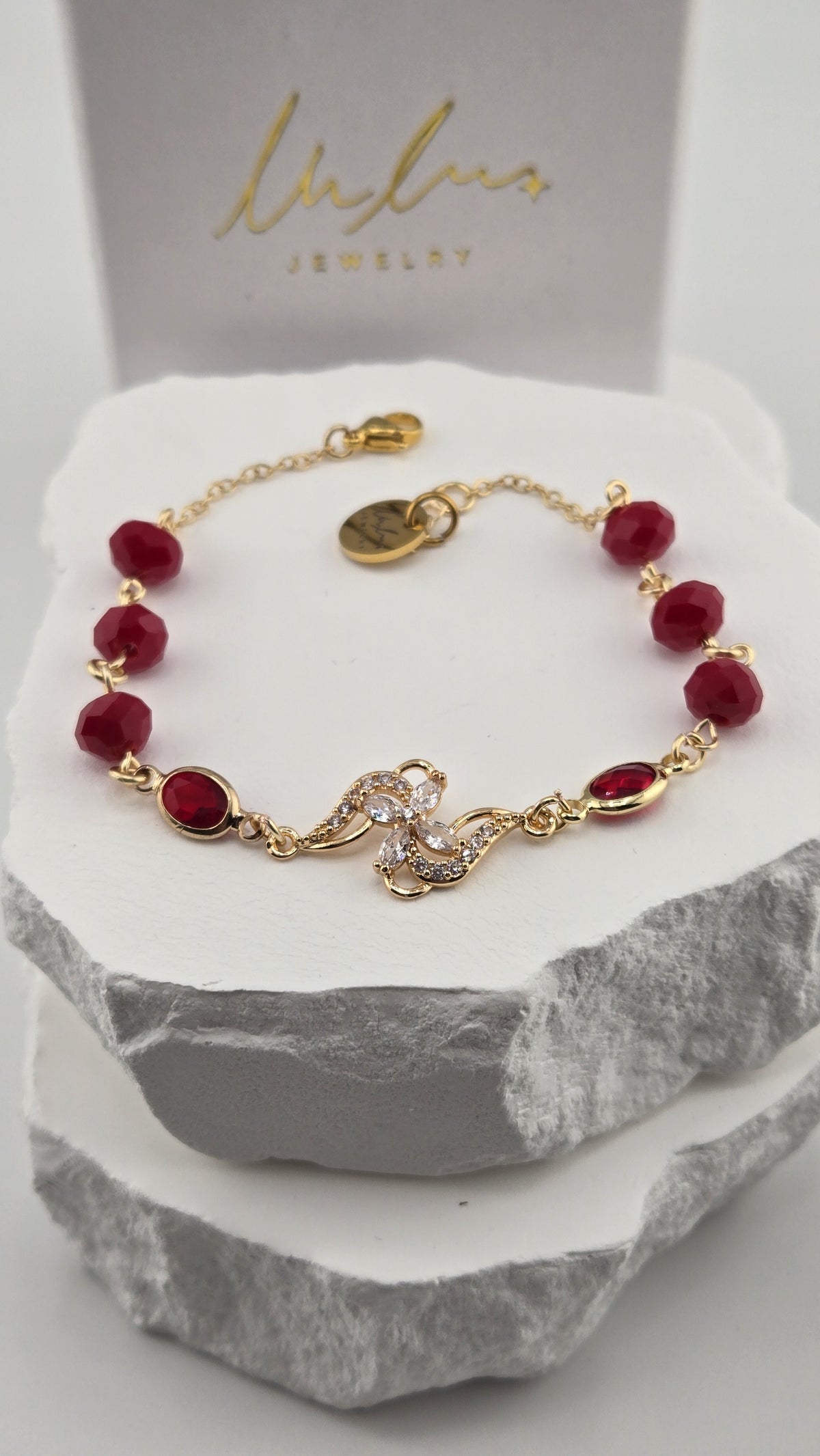 Hibiscus Pinwheel Bracelet with deep red beads and a gold flower centerpiece