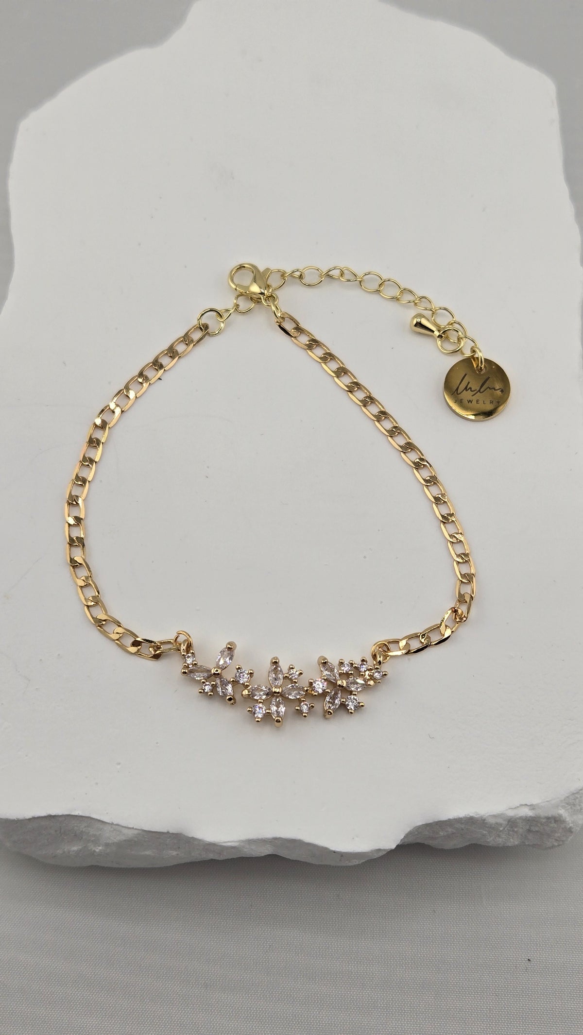 Jasmine Sprig Bracelet laid on a white stone with extender and LuluTouch tag