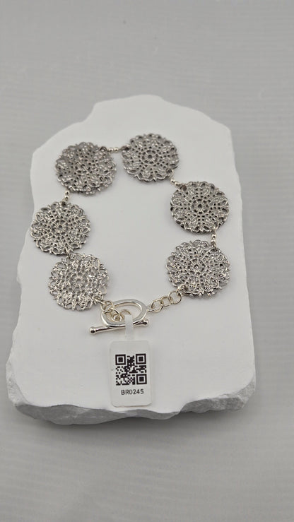 Six silver-tone openwork rosettes with toggle clasp