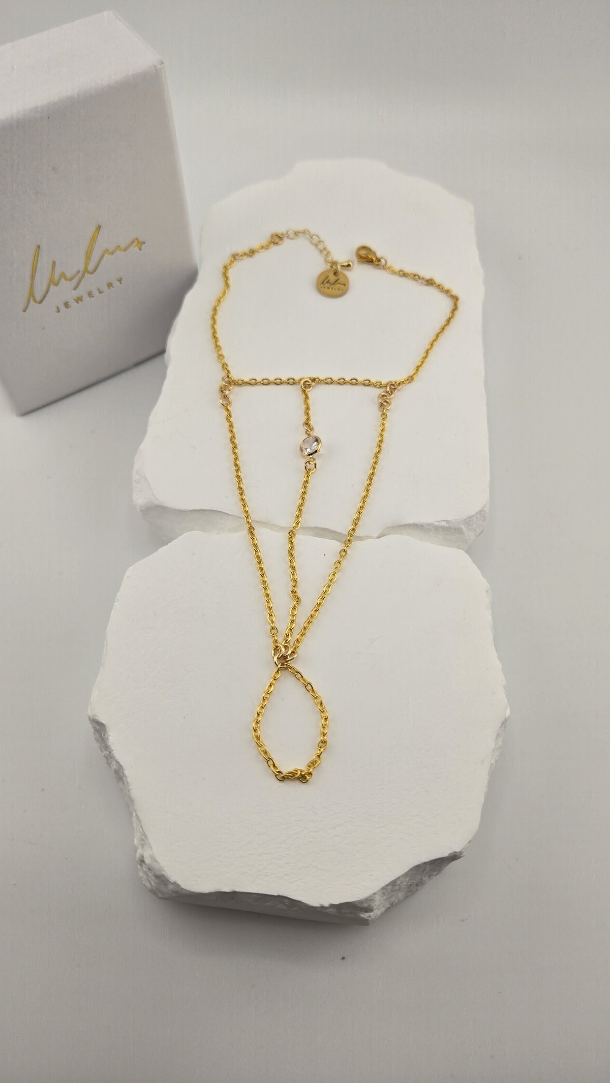 Solitaire Hand Chain laid flat on white stone