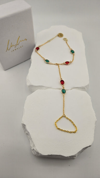 Sultana Hand Chain with red and green oval stones beside the LuluTouch box