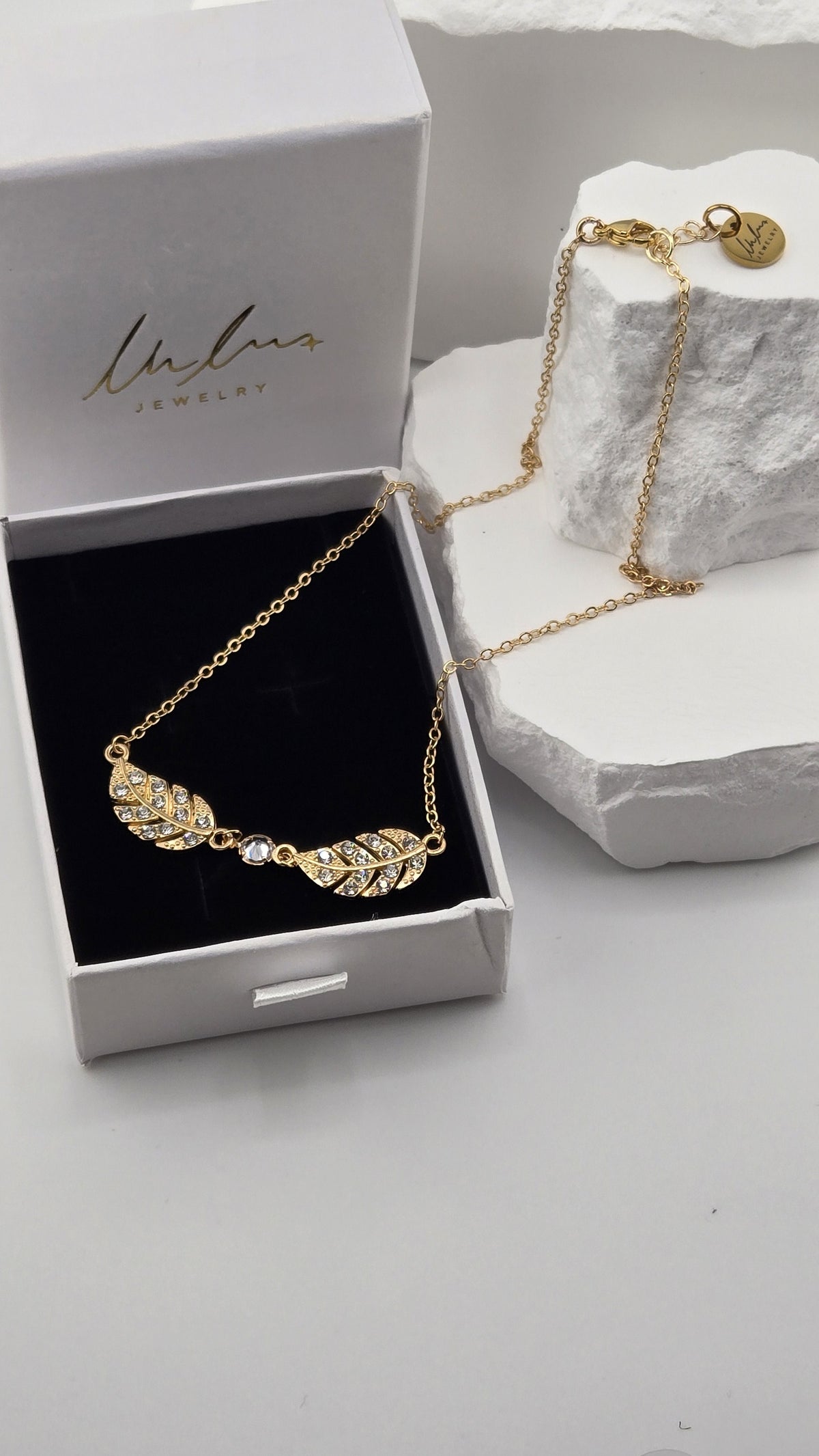 Twin Plume Necklace in a LuluTouch gift box, showing the gold-plated cable chain, lobster clasp and round LuluTouch tag
