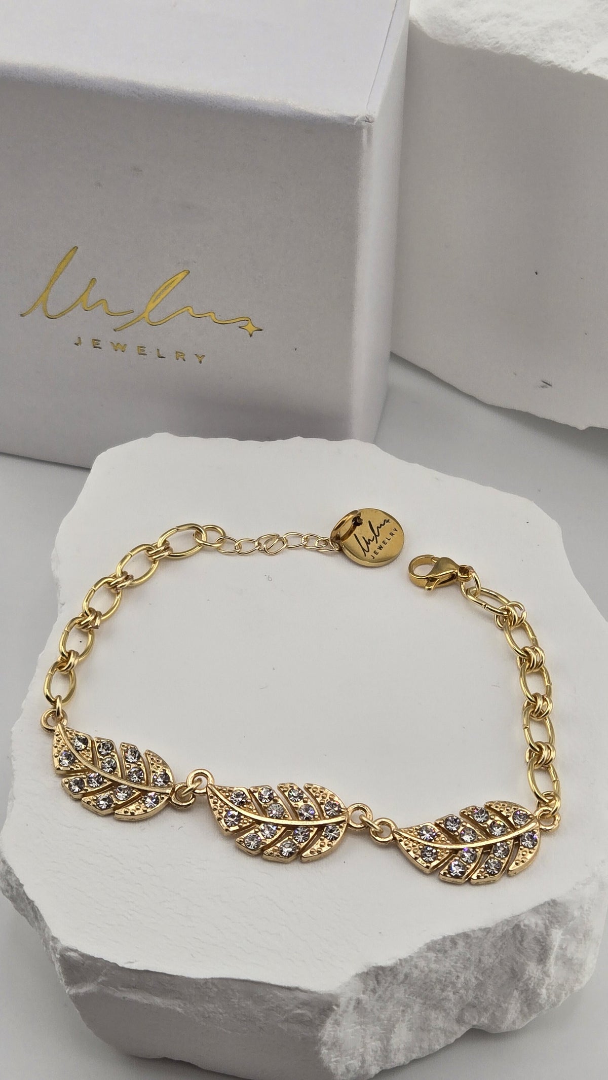 Wingtip Bracelet in front of a LuluTouch gift box, showing the lobster clasp, extender chain and round LuluTouch tag